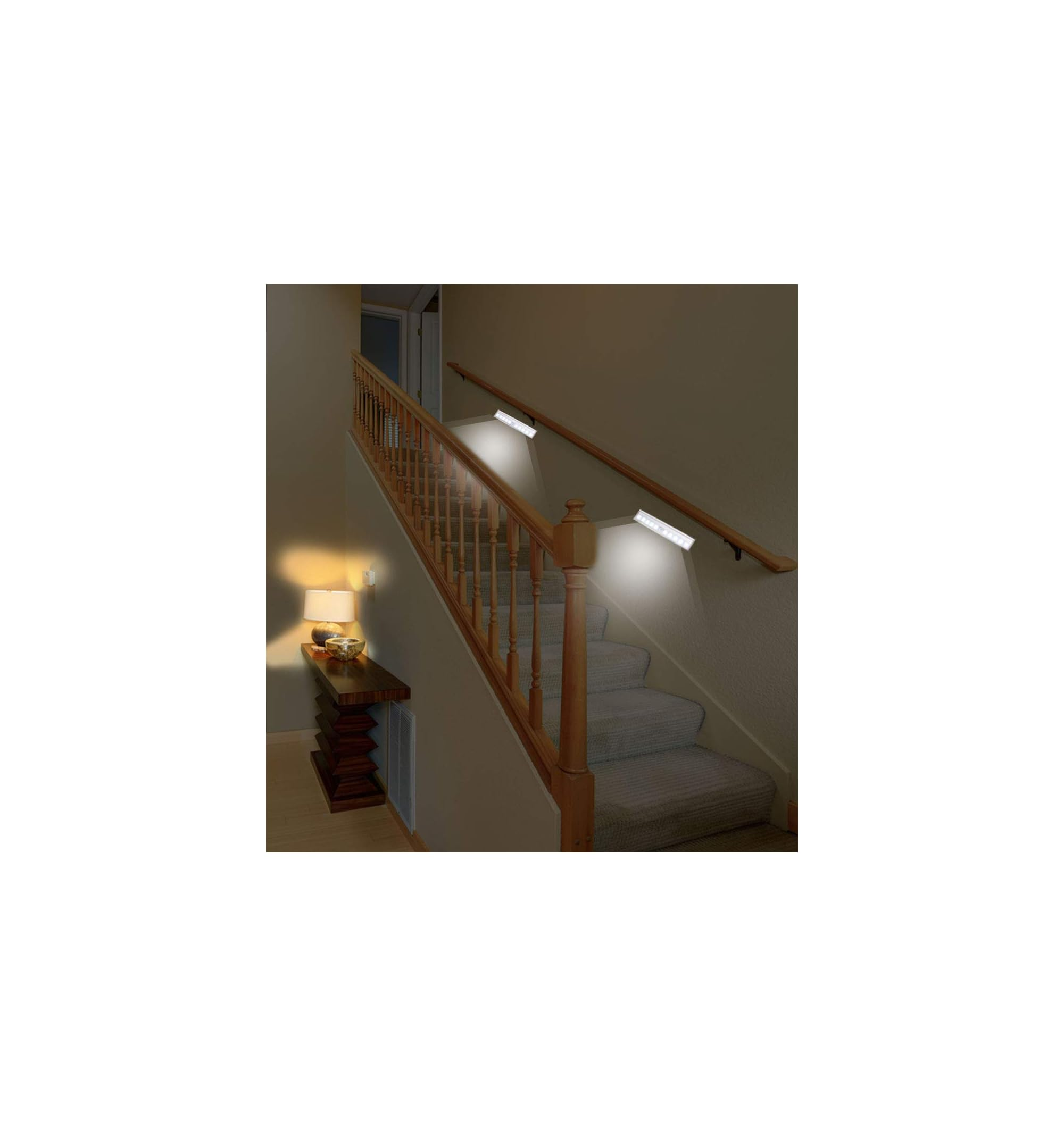 Beleuchtete Treppe mit Holzgeländer und zwei Wandleuchten.