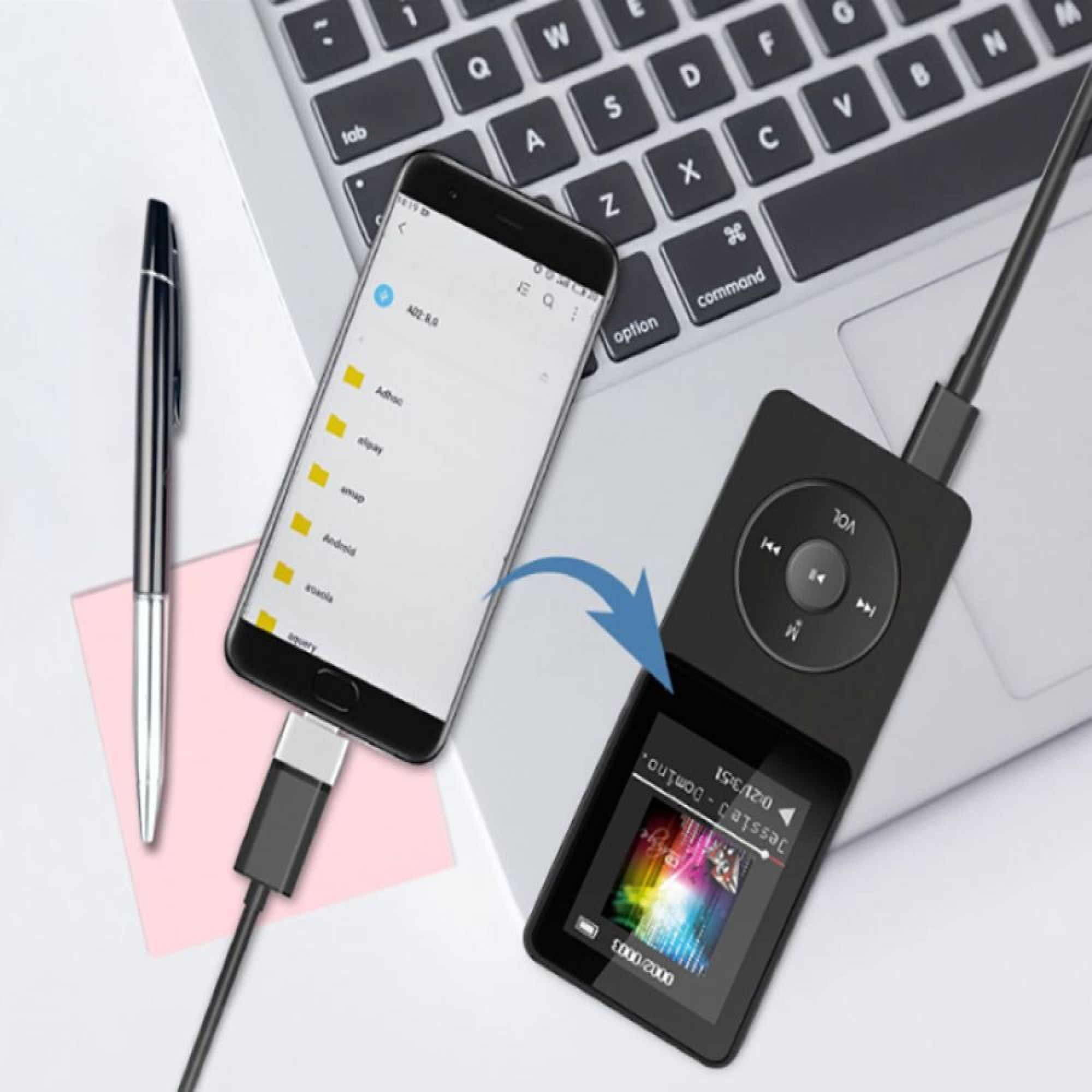 Ein Smartphone ist über ein Kabel mit einem MP3-Player verbunden, daneben ein Stift und Laptop.