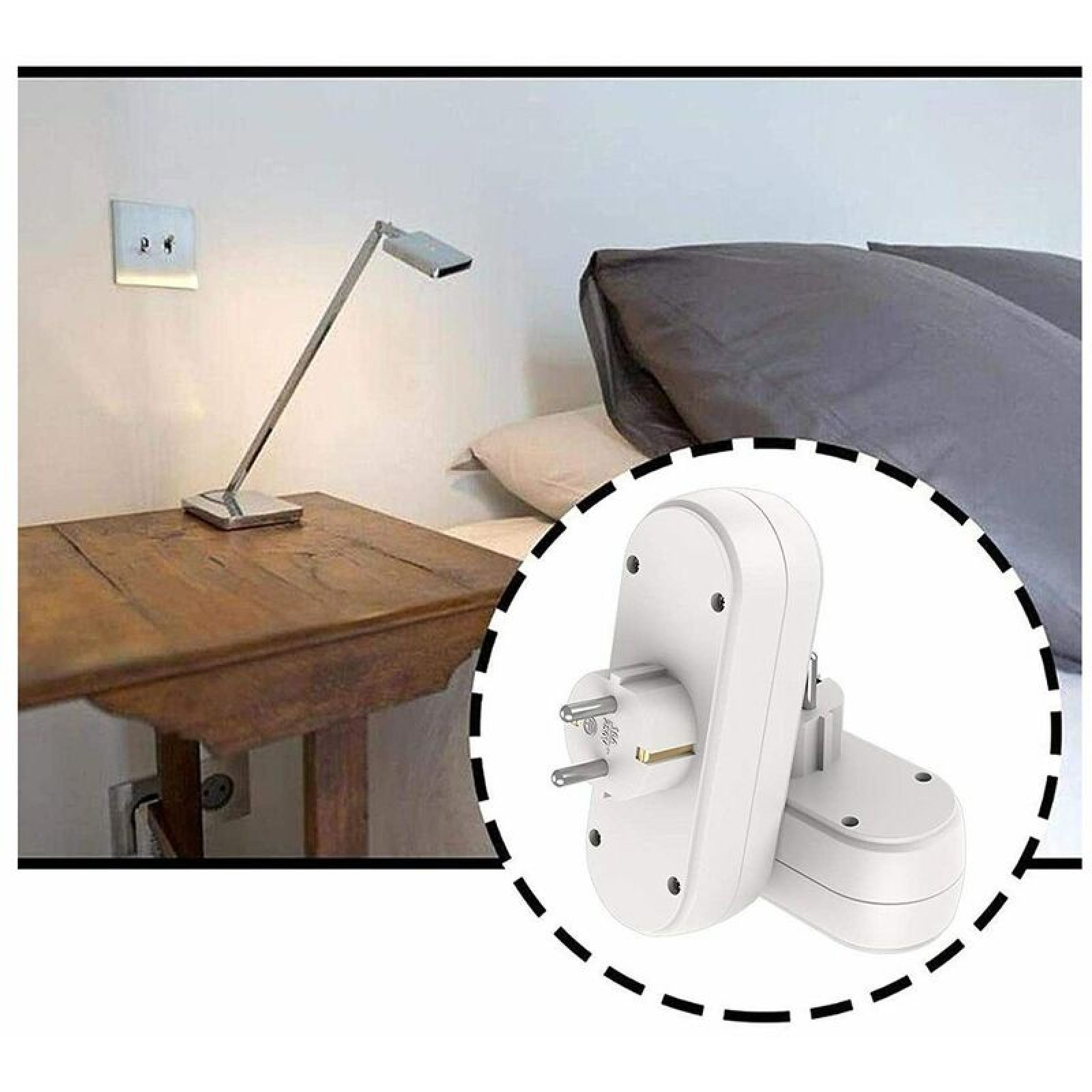 Ein weißer Steckdosenadapter mit zwei Steckplätzen neben einem Nachttisch und Bett.