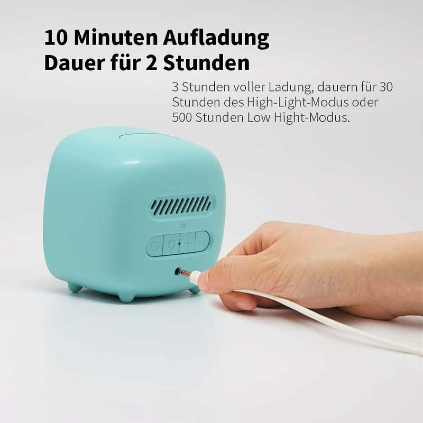 Ein hellblauer Wecker wird aufgeladen. Eine Hand steckt ein Kabel ein.