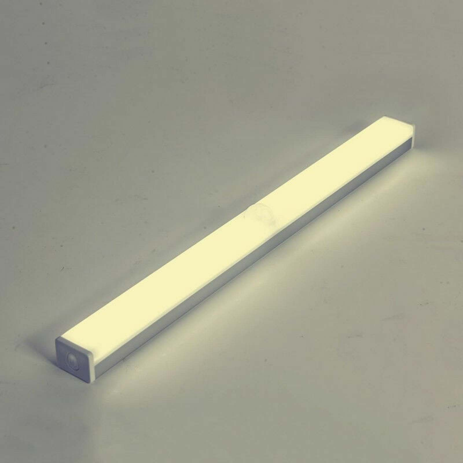 Ein schmaler, beleuchteter LED-Streifen mit silbernem Rahmen auf grauem Untergrund.