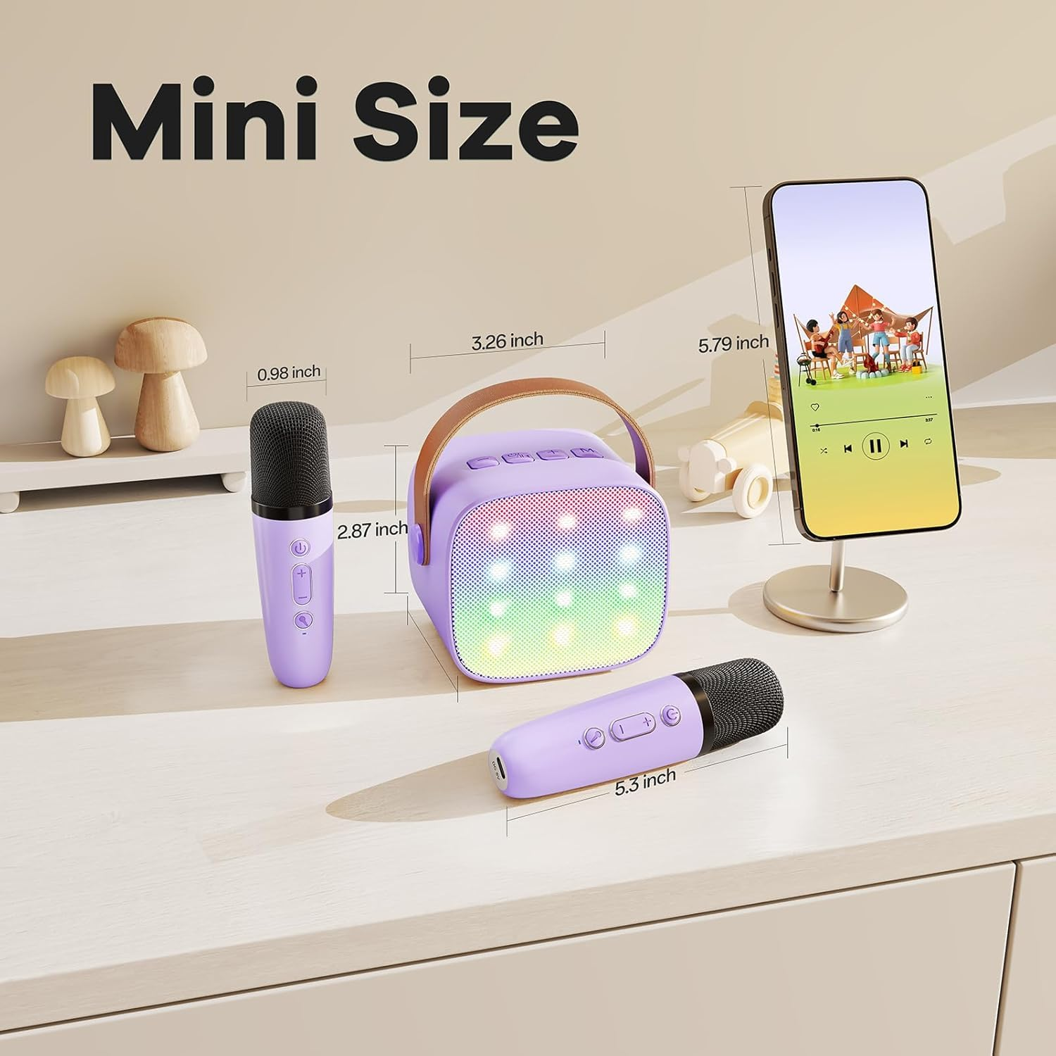 Lila Karaoke-Lautsprecher mit zwei Mikrofonen und Maßen, daneben ein Smartphone.