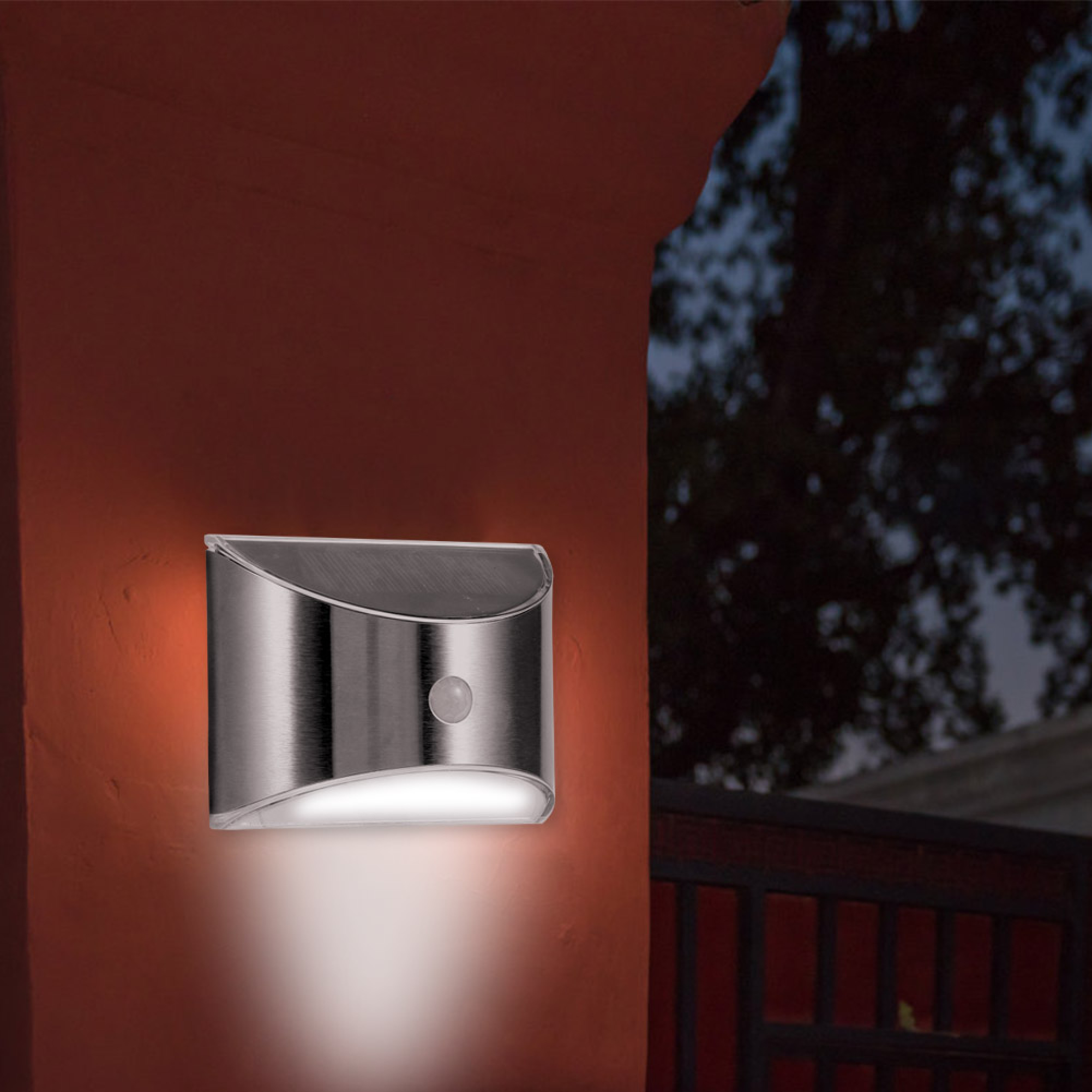 Eine silberne Solarleuchte mit Bewegungsmelder an einer braunen Wand.