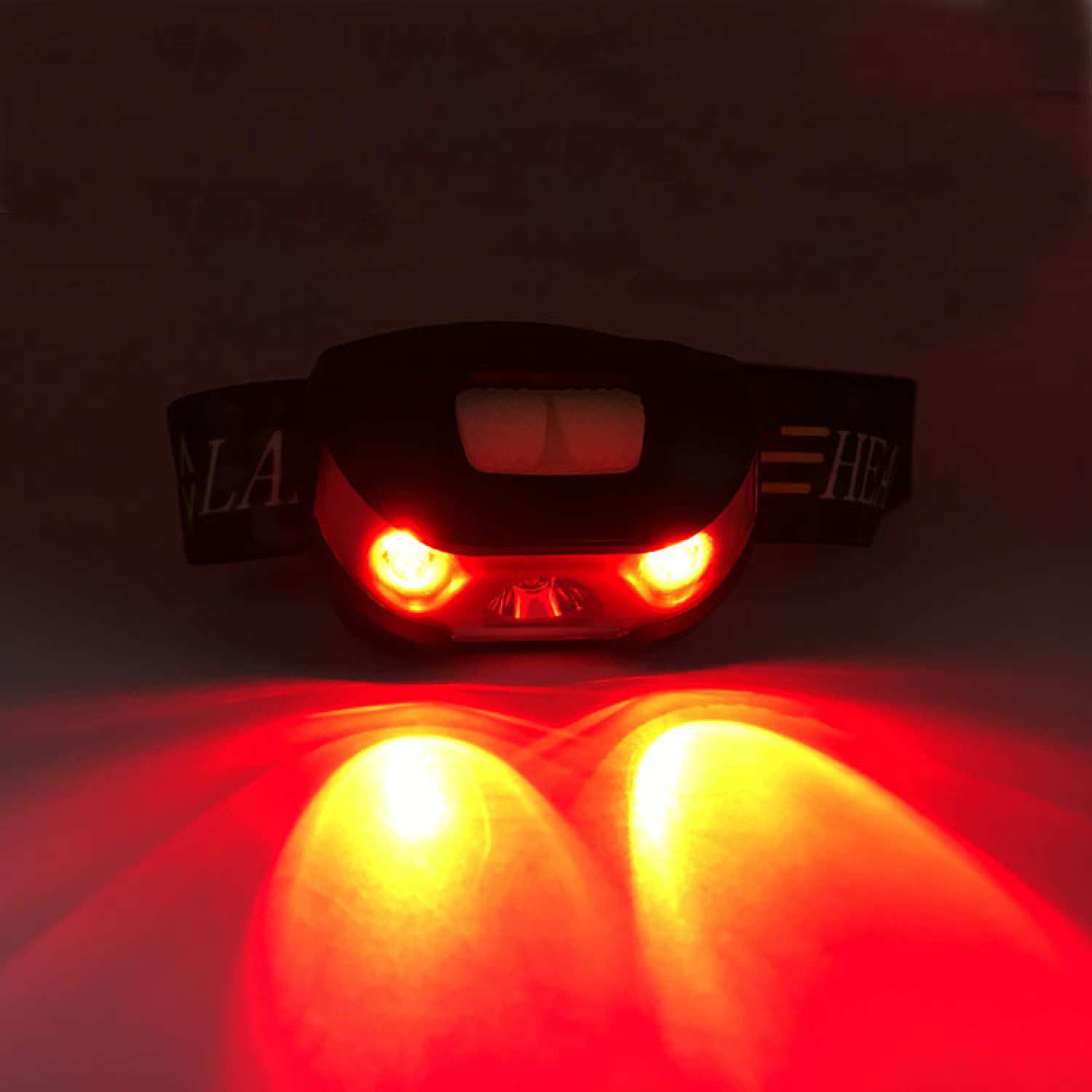 Ein schwarzer Stirnlampe mit roten Lichtern leuchtet.