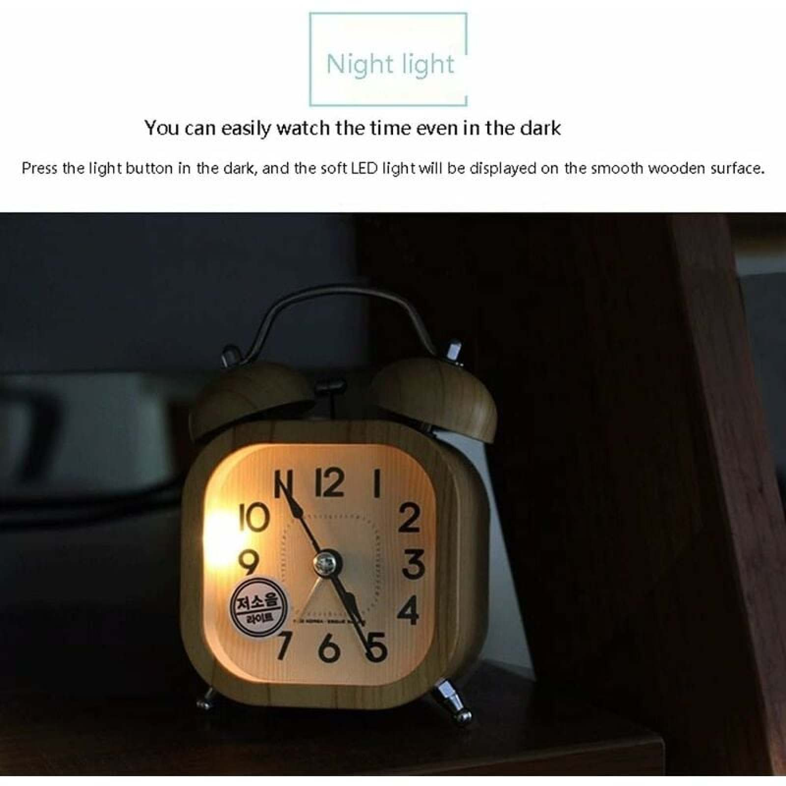 Ein hölzerner Wecker mit Nachtlichtfunktion leuchtet. Die Zeit ist ablesbar.