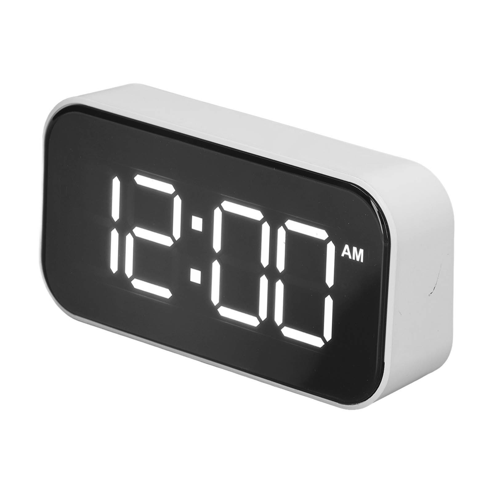 Ein weißer Digitalwecker zeigt 12:00 AM auf schwarzem Hintergrund.
