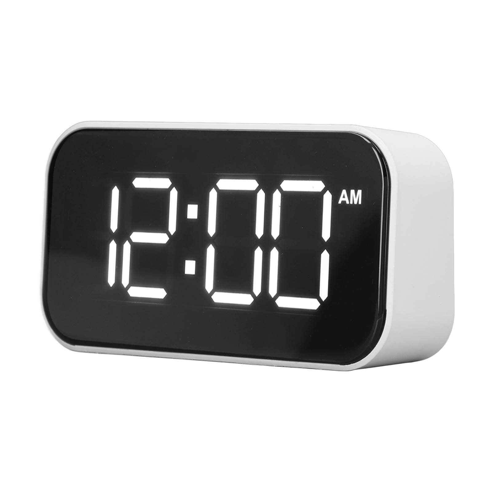 Ein digitaler Wecker zeigt 12:00 AM an. Er hat ein weißes Gehäuse.