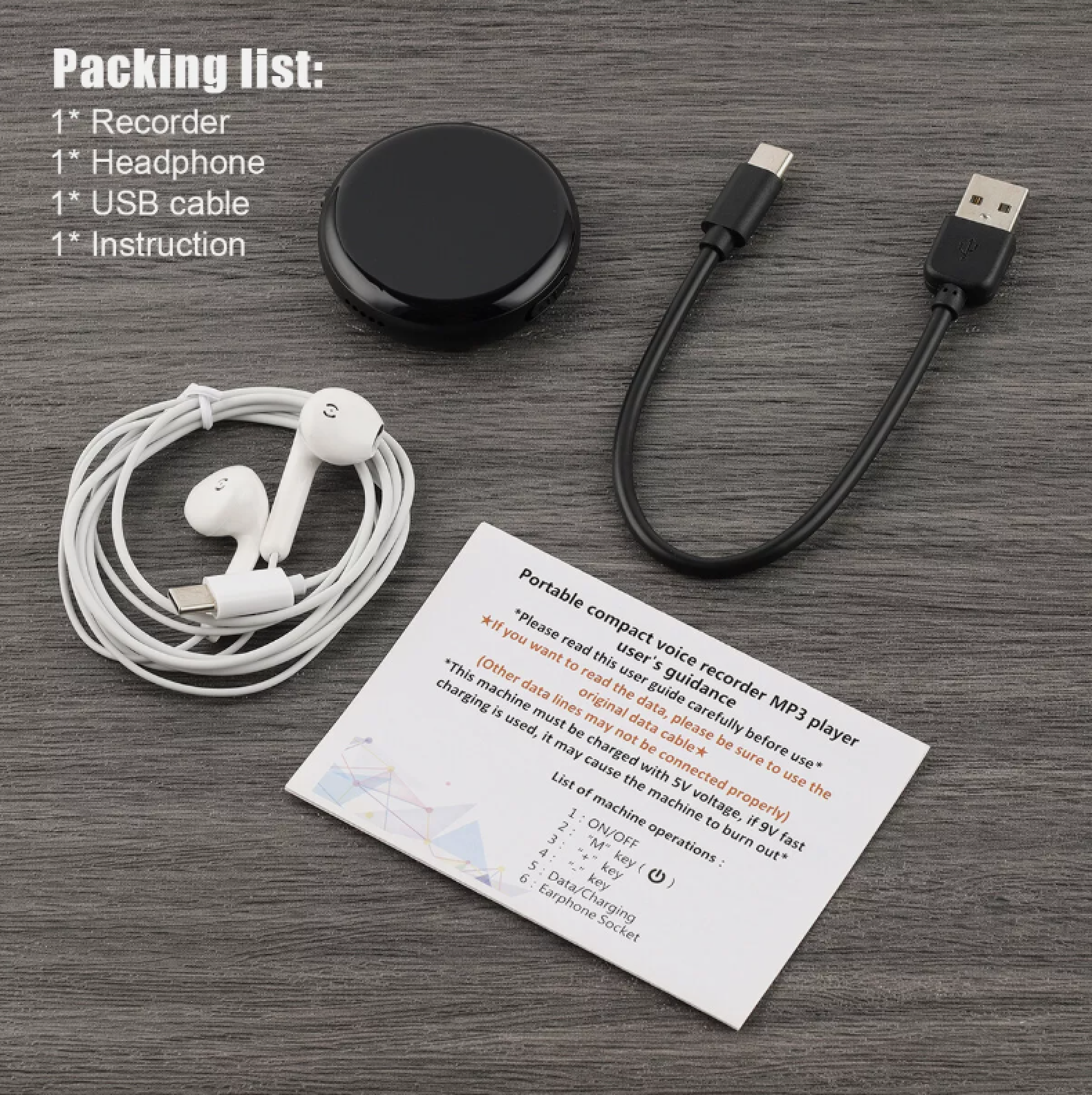 Ein schwarzer runder Rekorder, weiße Kopfhörer, USB-Kabel und Anleitung liegen auf grauem Holz.