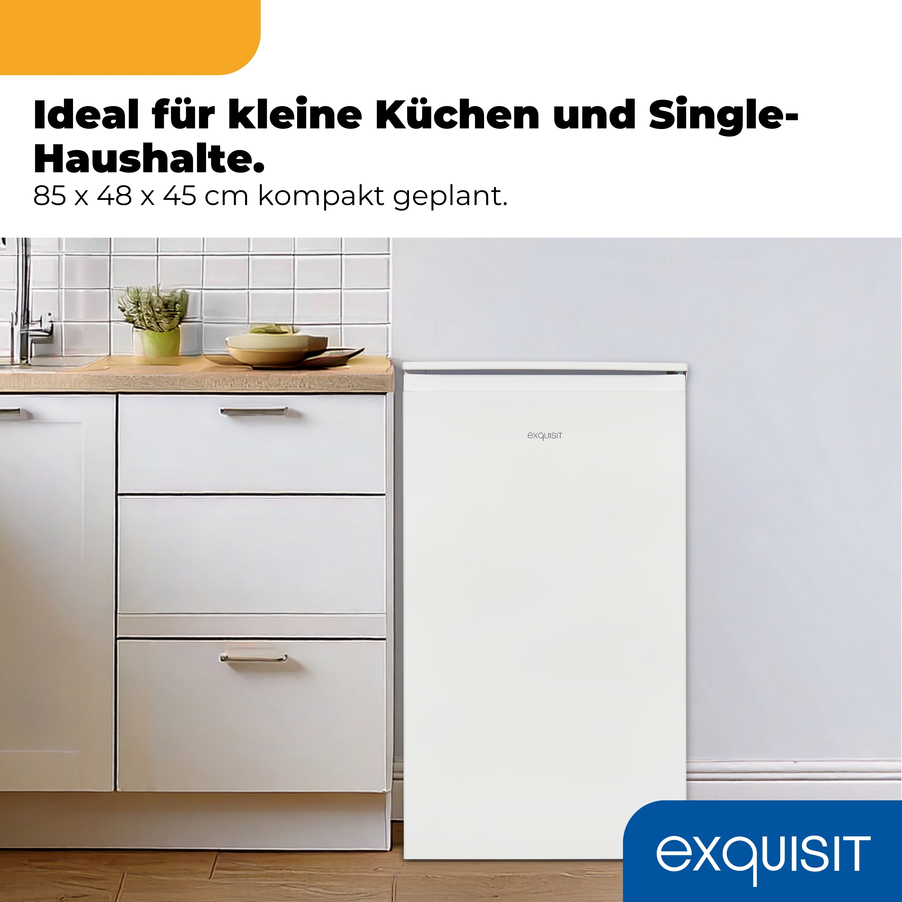Ein weißer Kühlschrank steht neben weißen Küchenschränken mit Schubladen.
