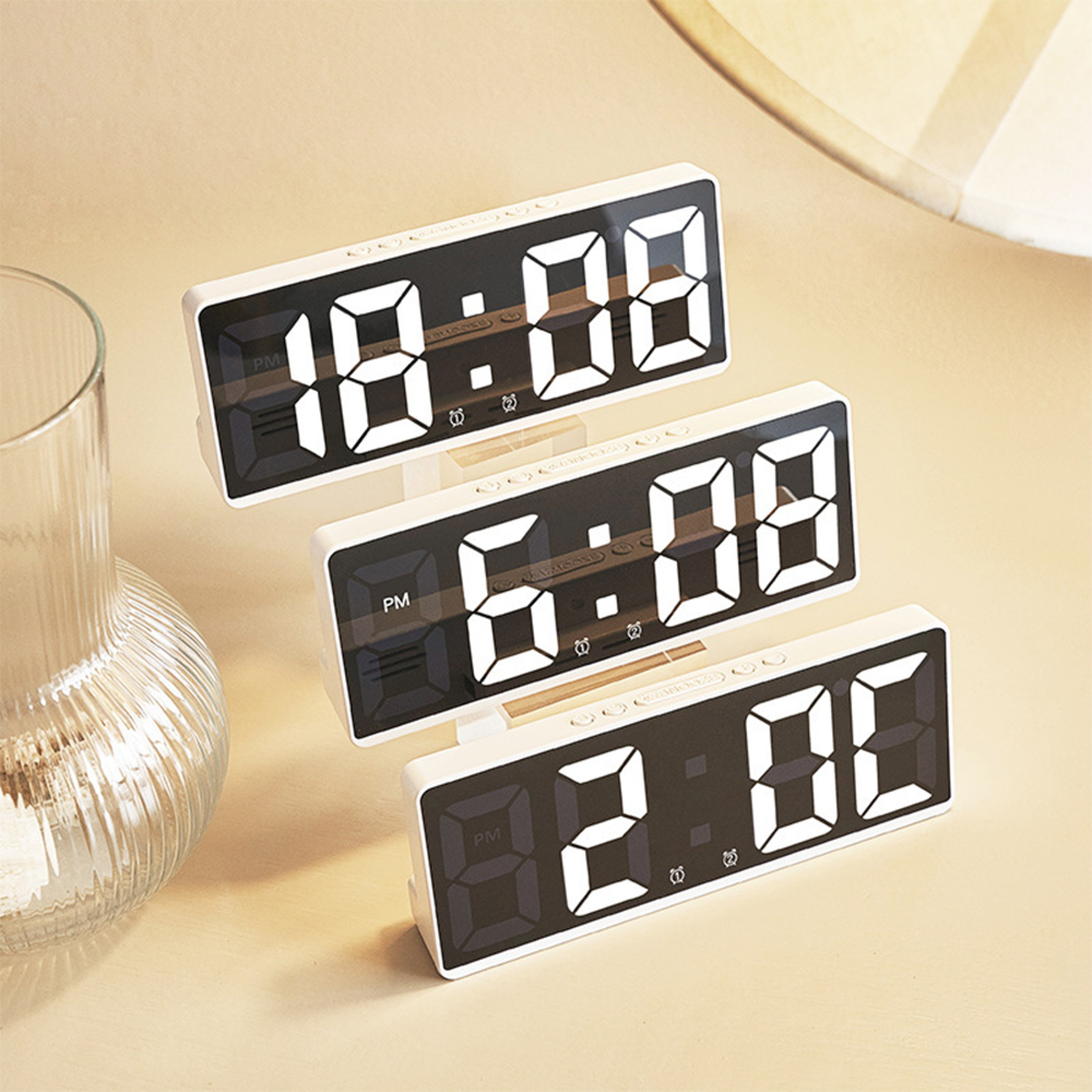 Drei digitale Wecker zeigen 18:08, 6:08 und 2:08 an. Eine Glasvase ist links.