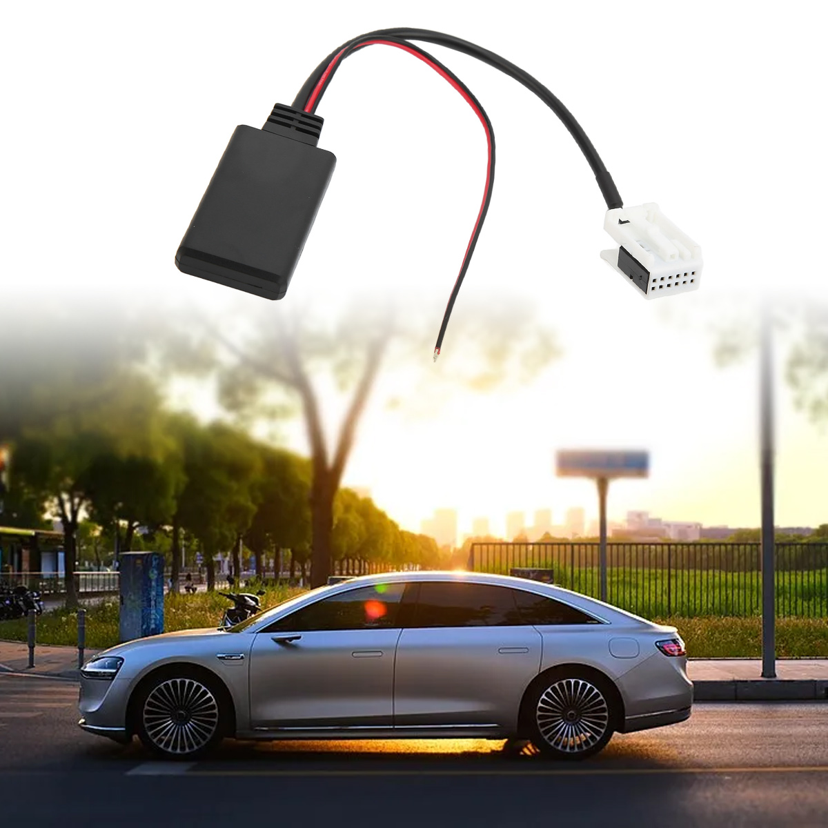 Ein schwarzer Bluetooth-Adapter mit Kabeln über einem silbernen Auto, das auf einer Straße fährt.