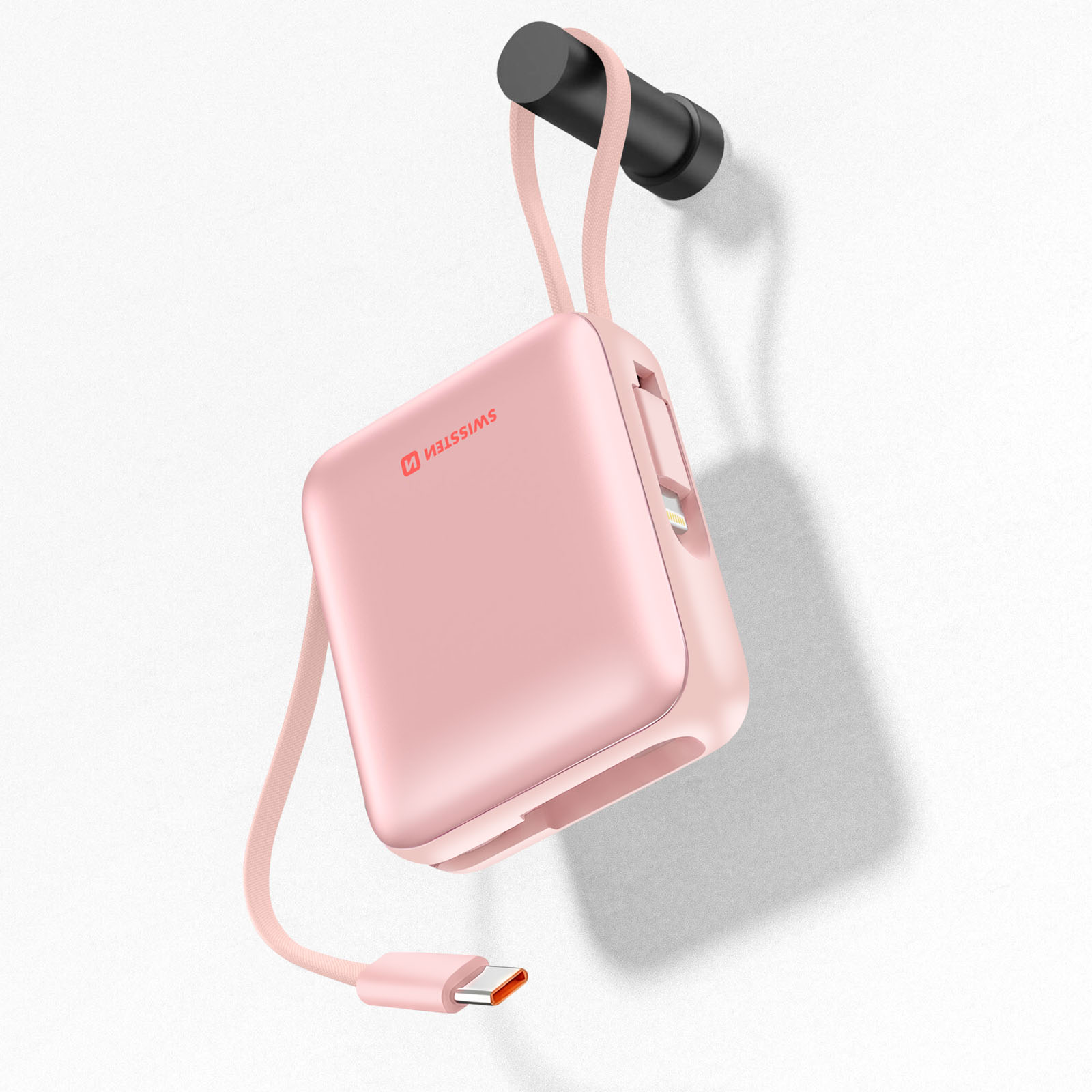 Un power bank compatto rosa con cavo integrato appeso a un gancio.