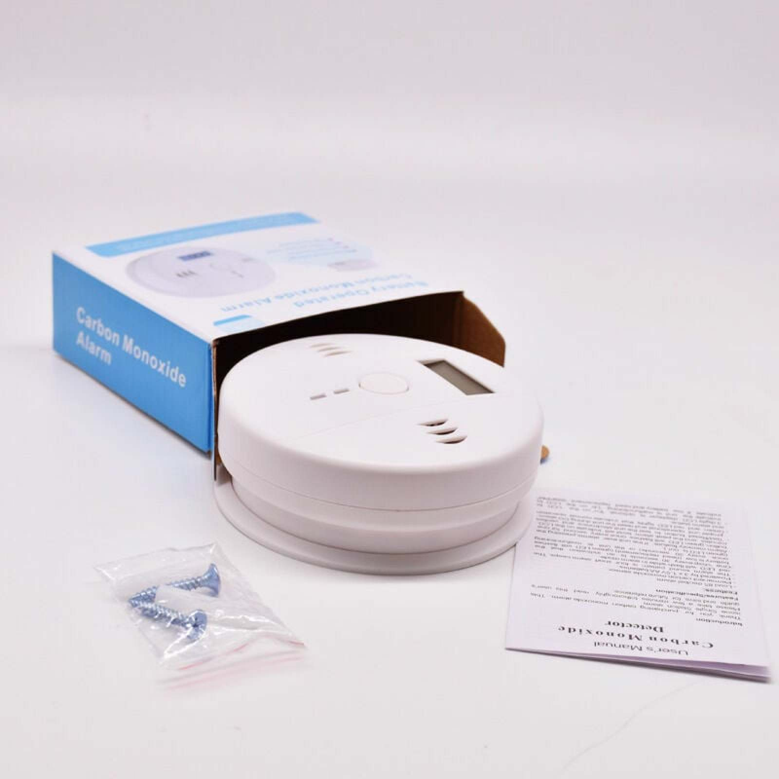 Ein weißer Kohlenmonoxid-Alarm liegt neben einer geöffneten blauen Box.