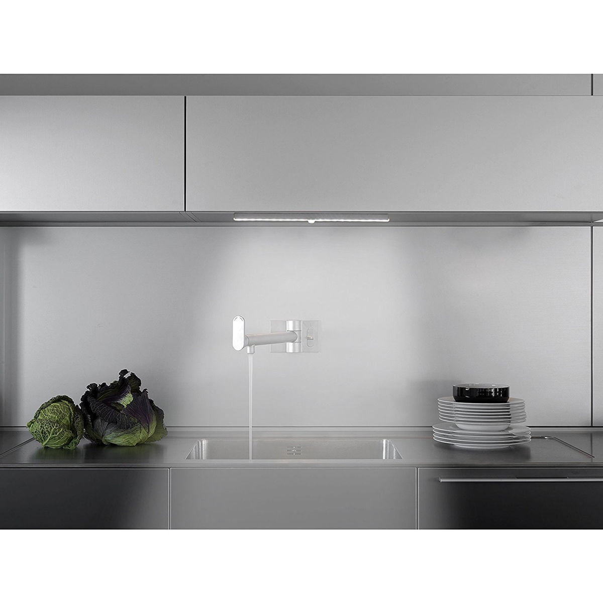 Moderne Küche mit Edelstahlspüle, Armatur, Gemüse und Geschirr.