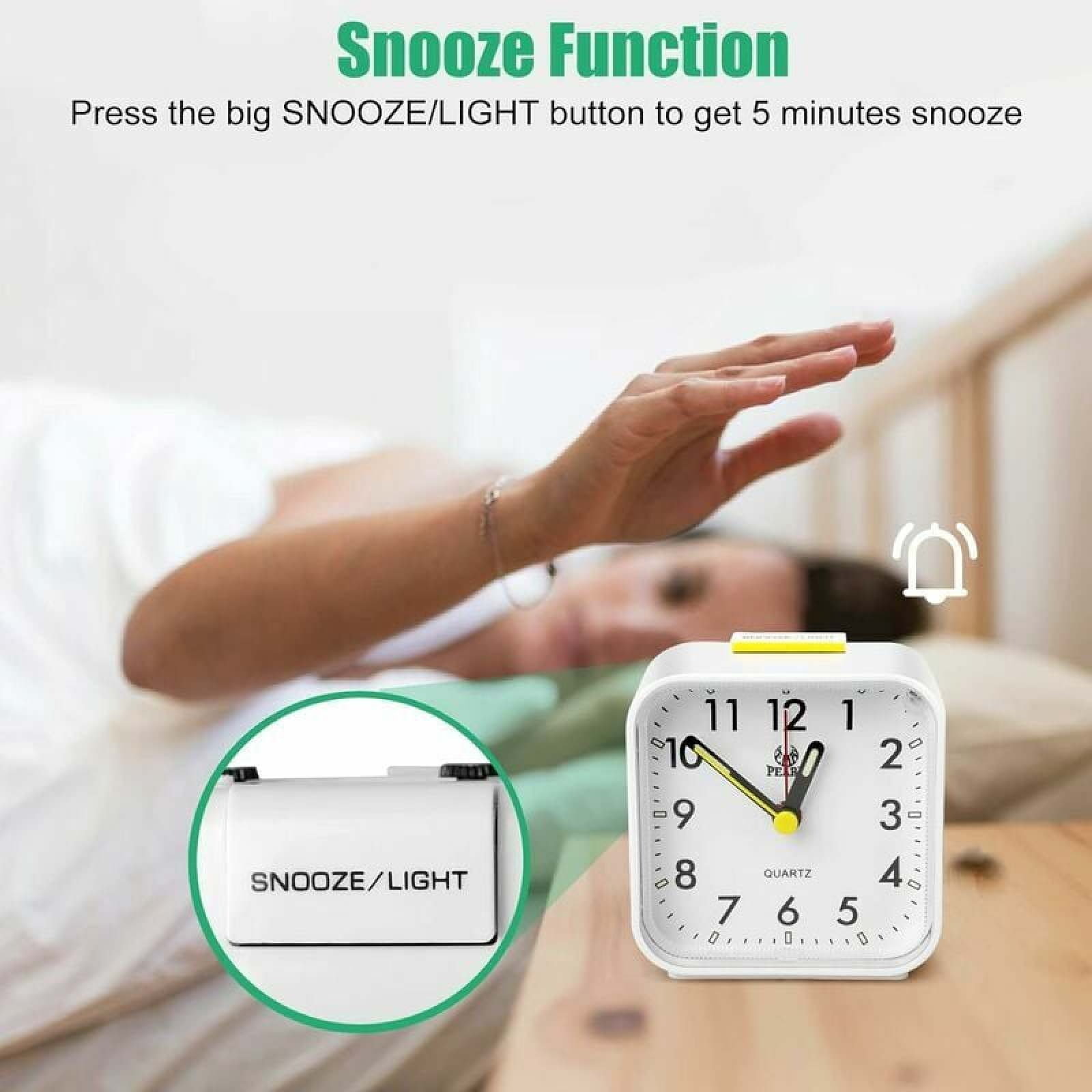 Ein Wecker mit Snooze-Funktion liegt auf einem Nachttisch, eine Hand greift danach.