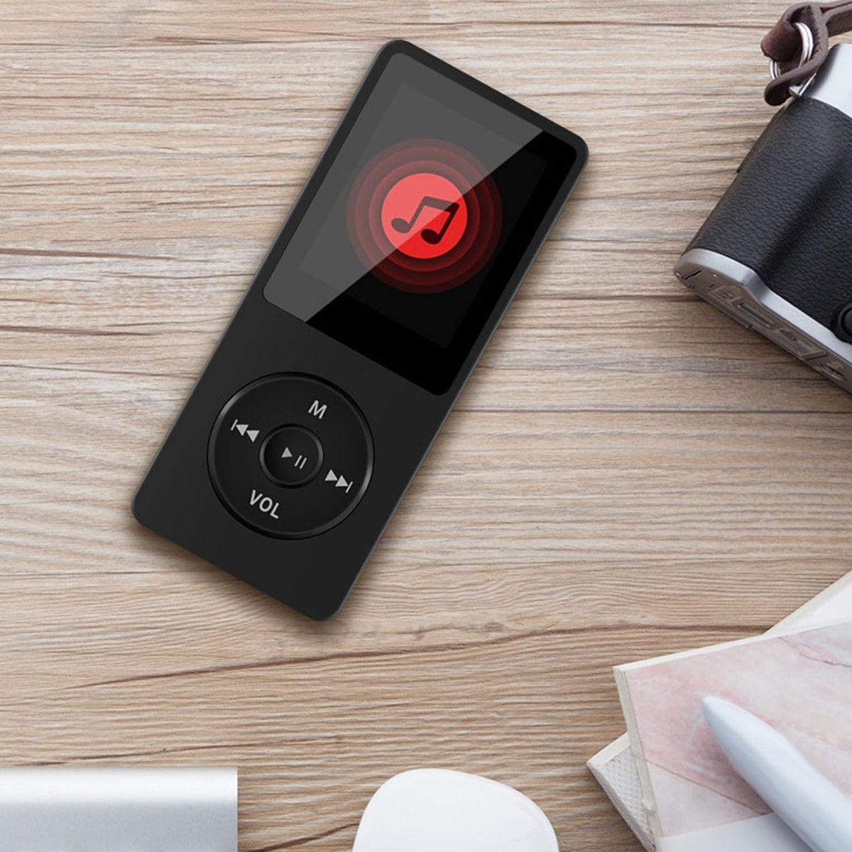 Schwarzer MP3-Player auf Holztisch mit Musiknotensymbol.