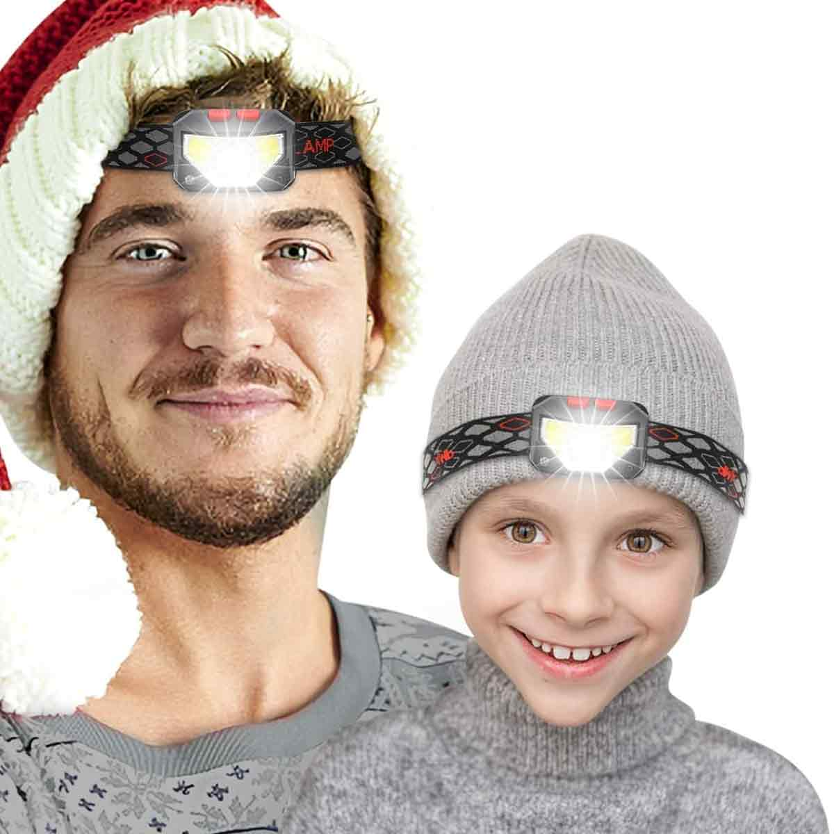 Mann mit Weihnachtsmütze und Kind mit Mütze, beide tragen Stirnlampen.