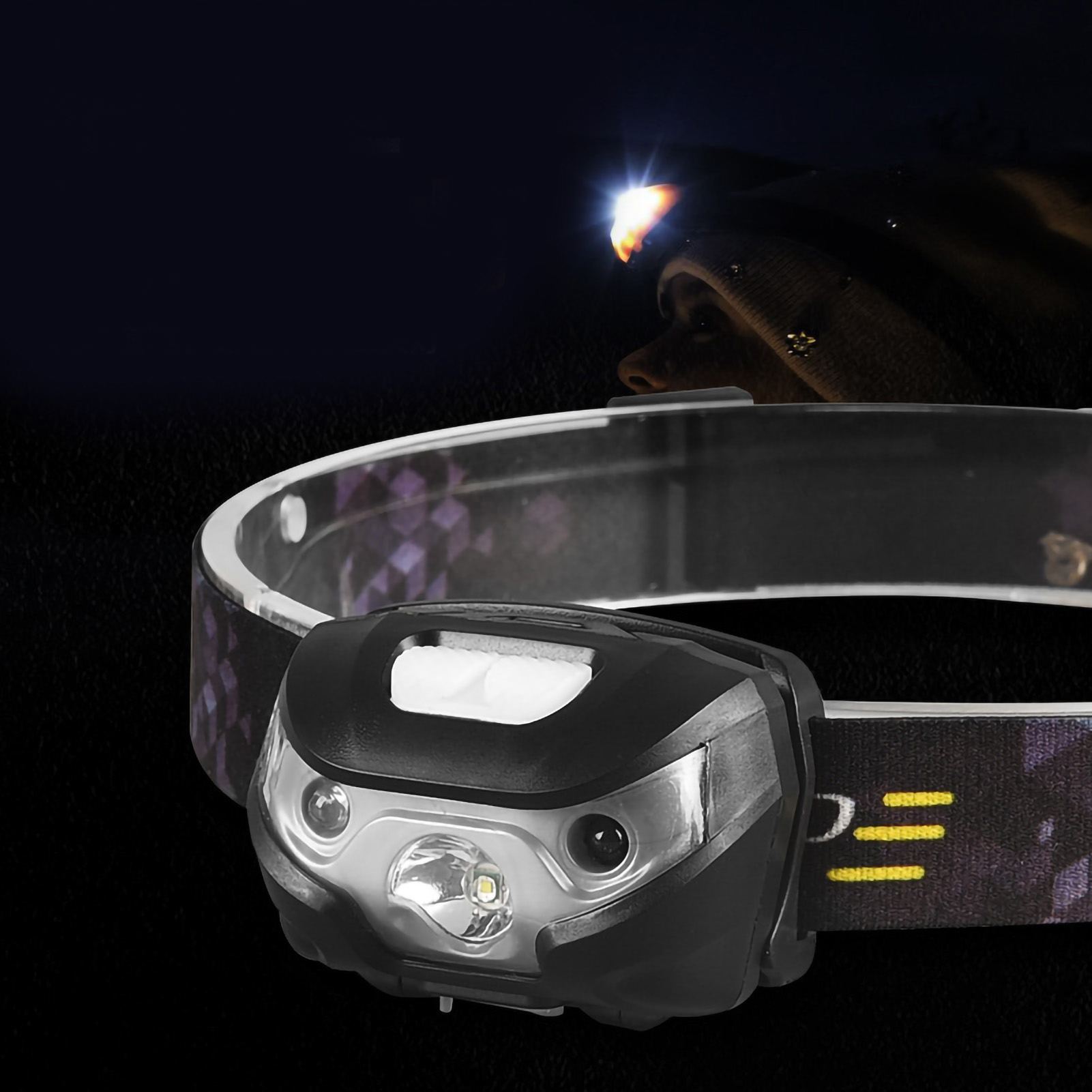 Nahaufnahme einer Stirnlampe mit schwarzem Gehäuse und einer hellen LED, die auf ein dunkles Band leuchtet.