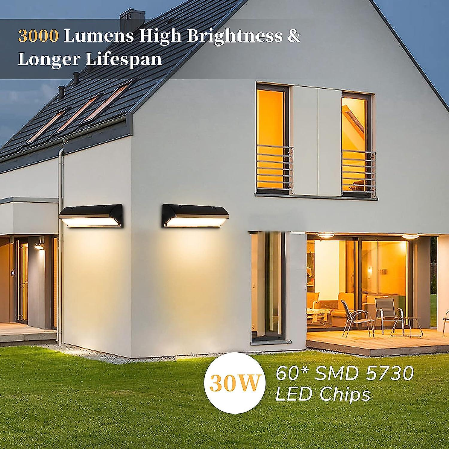 Modernes Hausaußen mit zwei Wandleuchten, die die Fassade beleuchten.