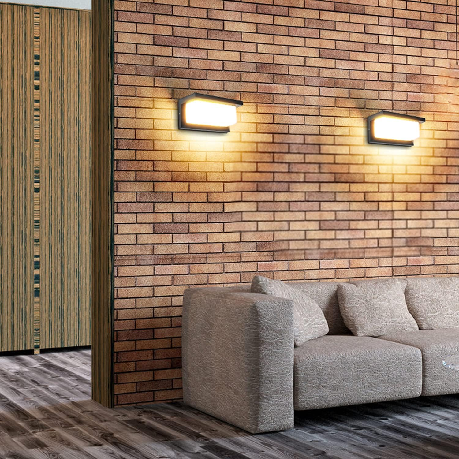 Ein Sofa vor einer Ziegelwand mit zwei Wandleuchten. Holztür links.