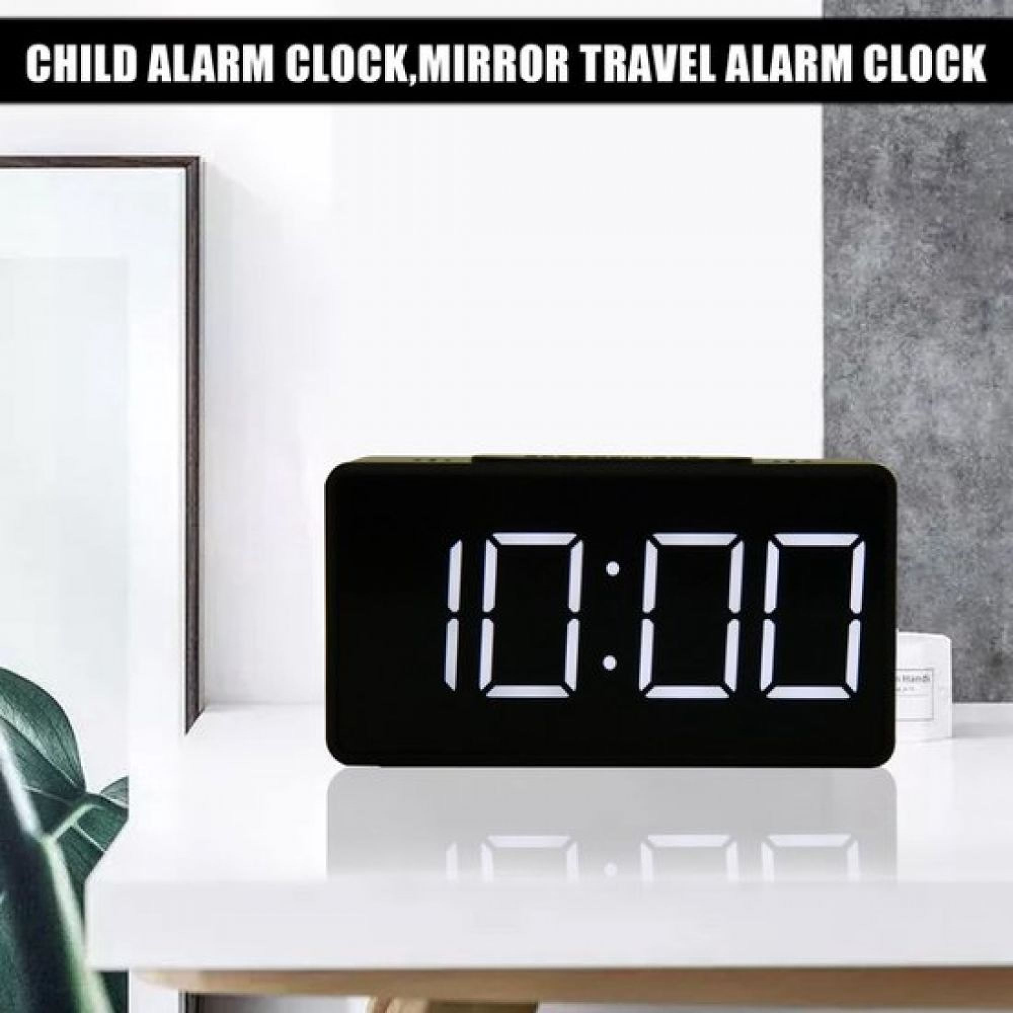 Ein schwarzer Digitalwecker zeigt 10:00 auf einem weißen Tisch.