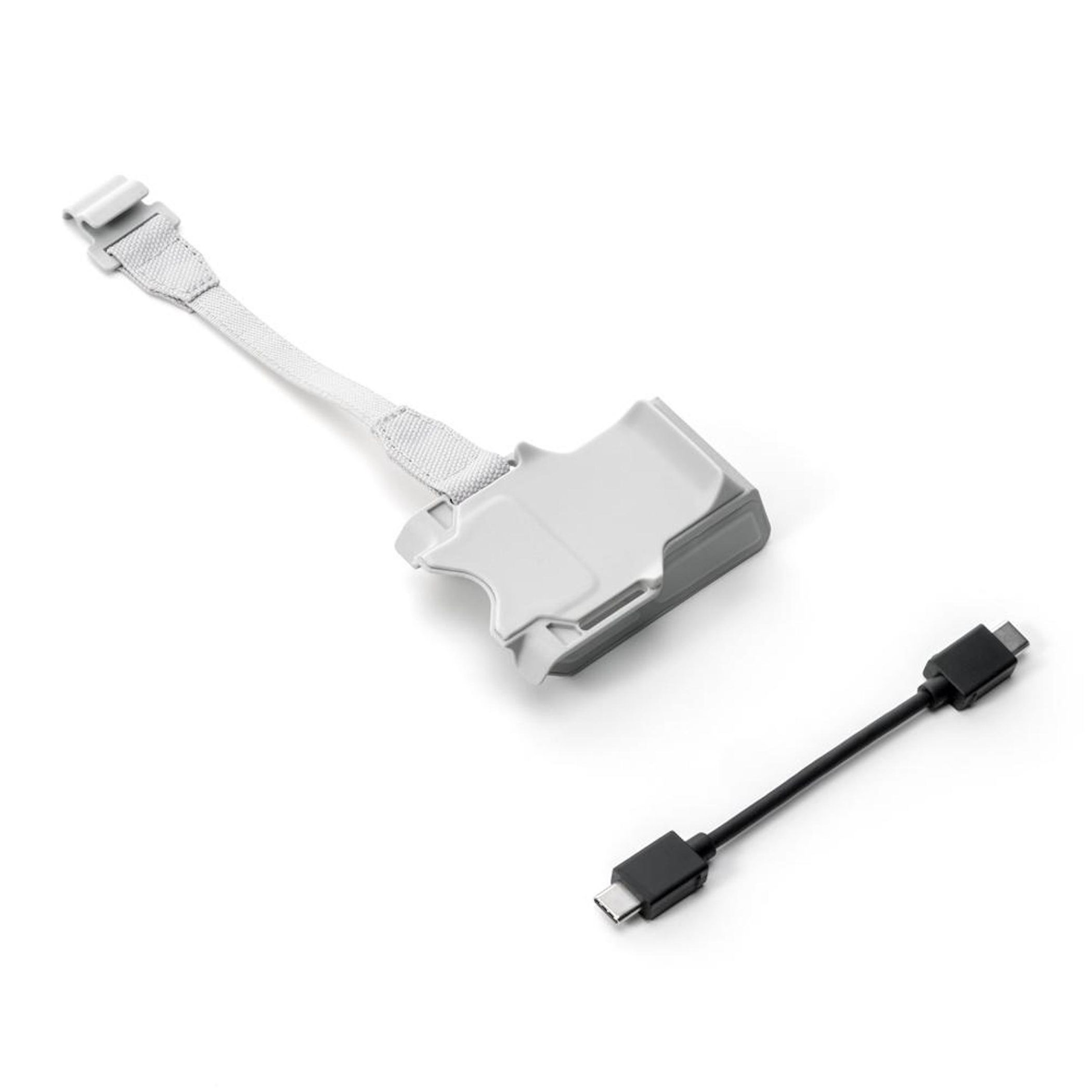 Ein graues Drone-Zubehörteil mit Kabel und ein schwarzes USB-C-Kabel auf weißem Hintergrund.