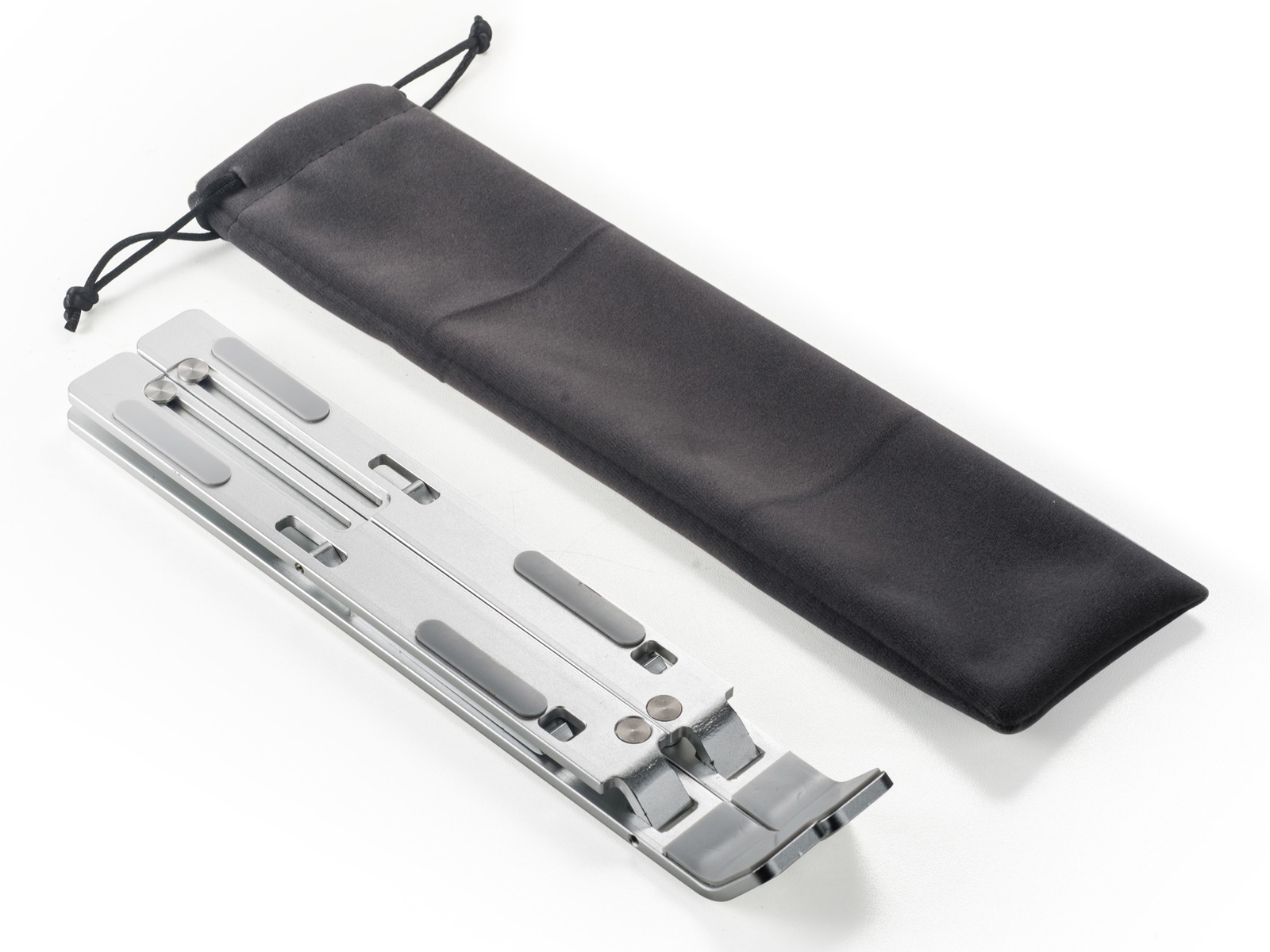 Ein zusammenklappbarer Laptopständer aus Silbermetall mit grauen Gummipads und einer schwarzen Stofftasche.