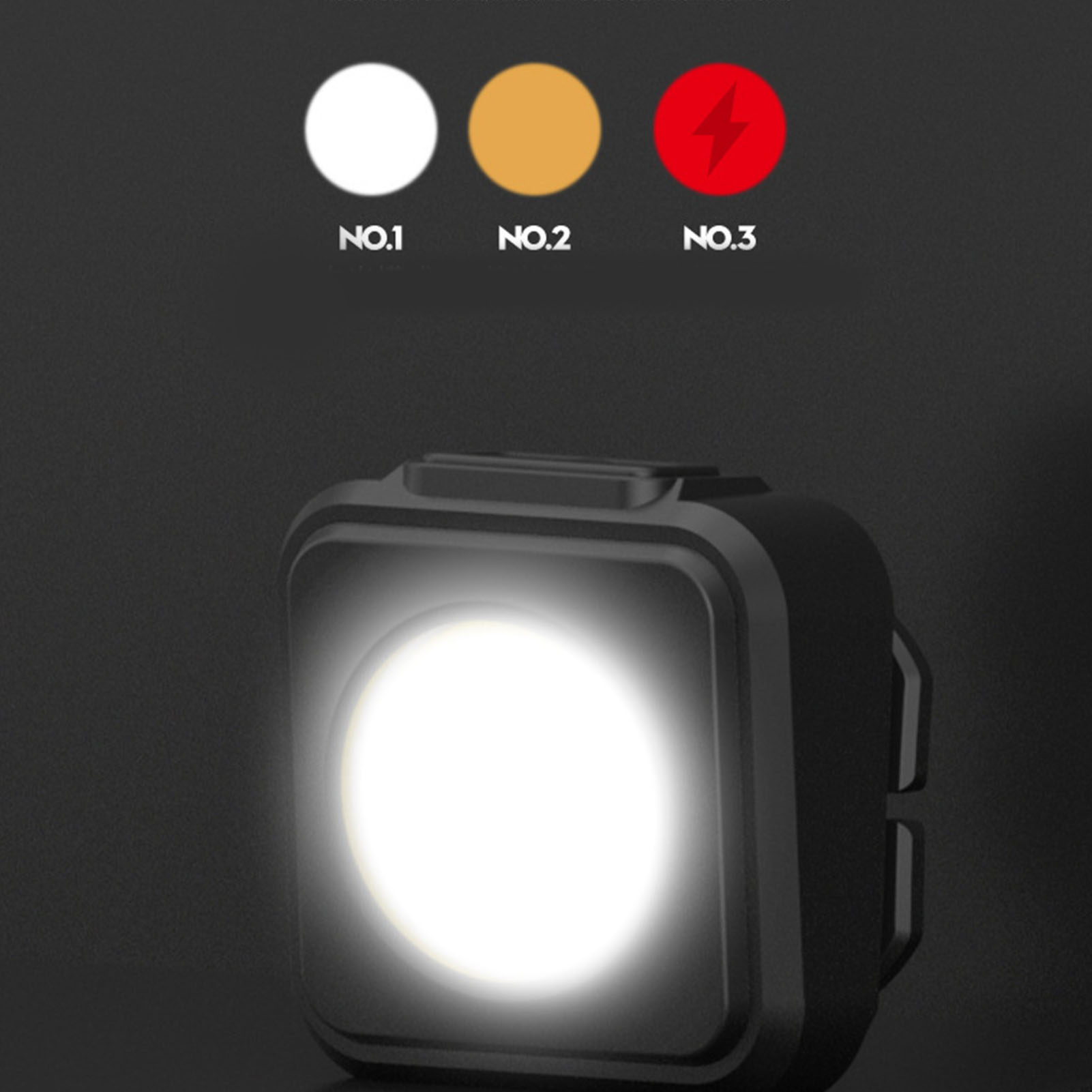 Ein schwarzes Gerät mit einem hellen Licht leuchtet. Oben sind drei Kreise: weiß, gelb, rot mit Blitz.