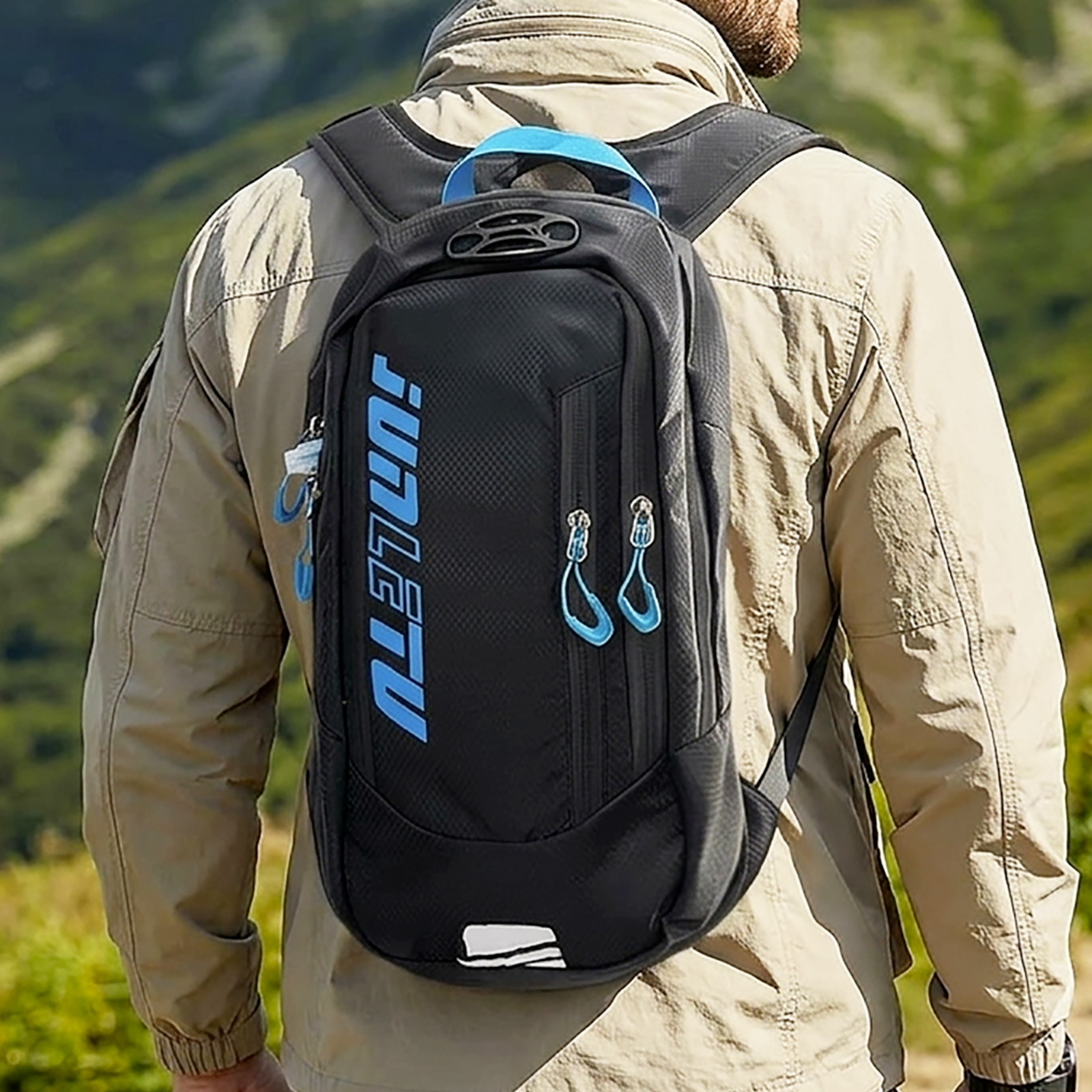 Mann mit schwarzem Rucksack mit blauen Akzenten, der in einer Berglandschaft geht.
