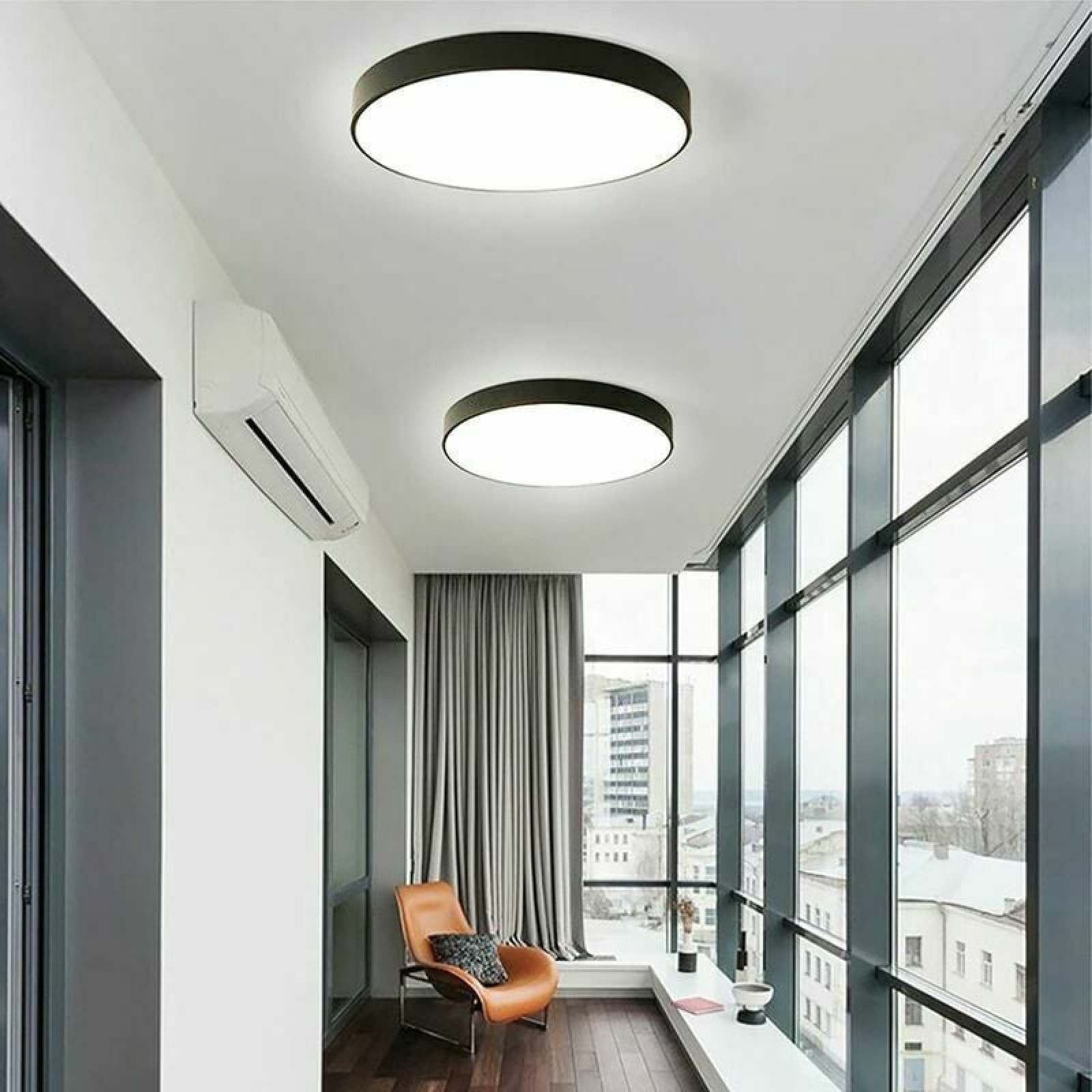Moderner Balkon mit zwei runden Deckenleuchten, Klimaanlage und Glasfront.