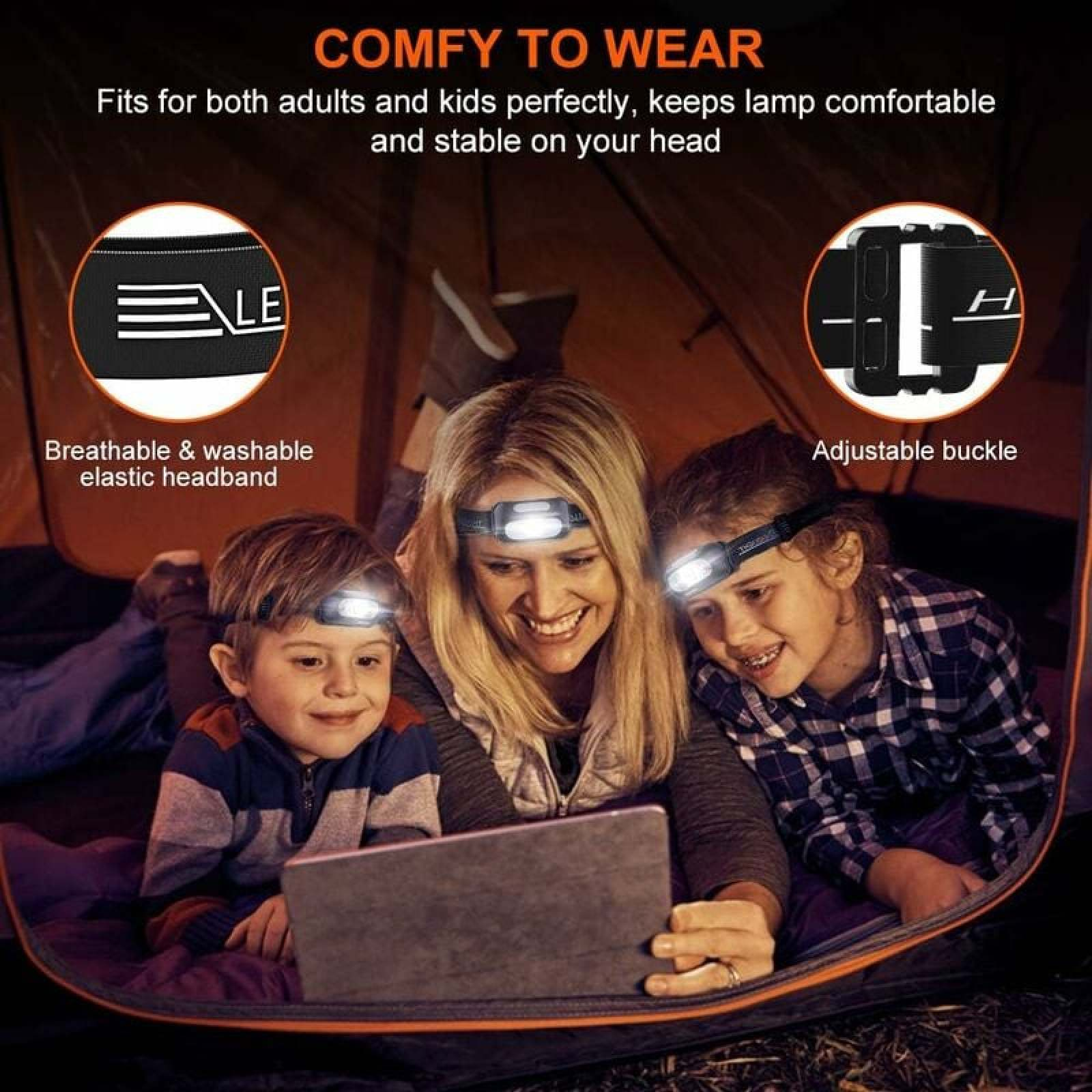 Familie in einem Zelt mit Stirnlampen, die auf ein Tablet schauen.