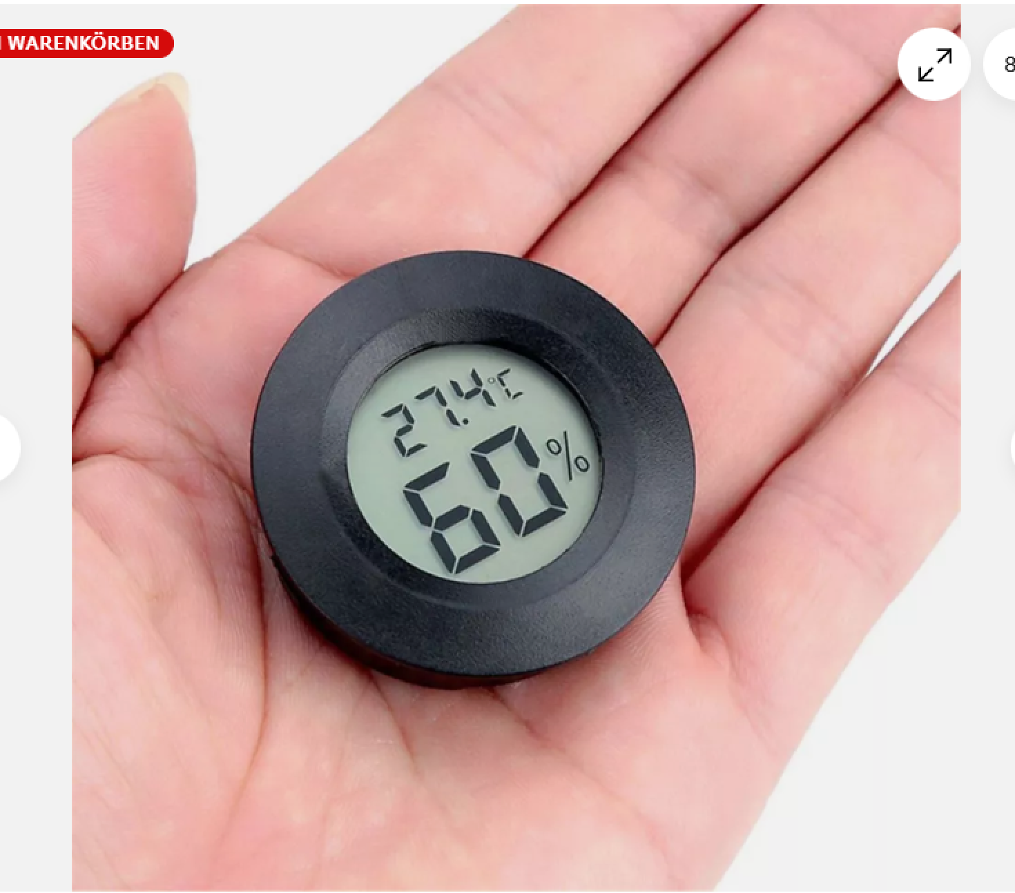 Ein kleiner digitaler Thermometer/Hygrometer wird in der Hand gehalten.
