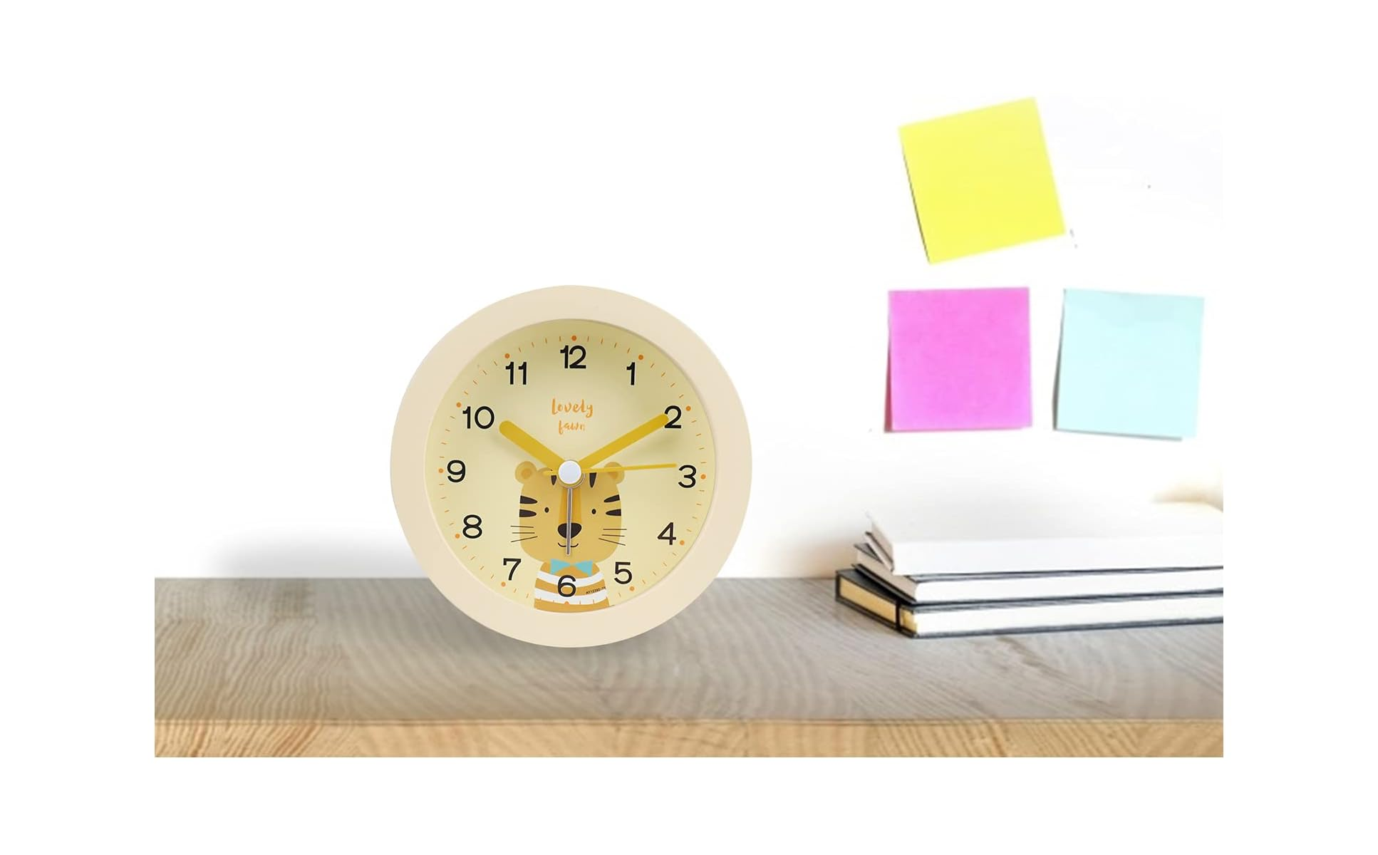 Eine runde Uhr mit einem Tigergesicht und gelben Zeigern auf einem Holztisch.