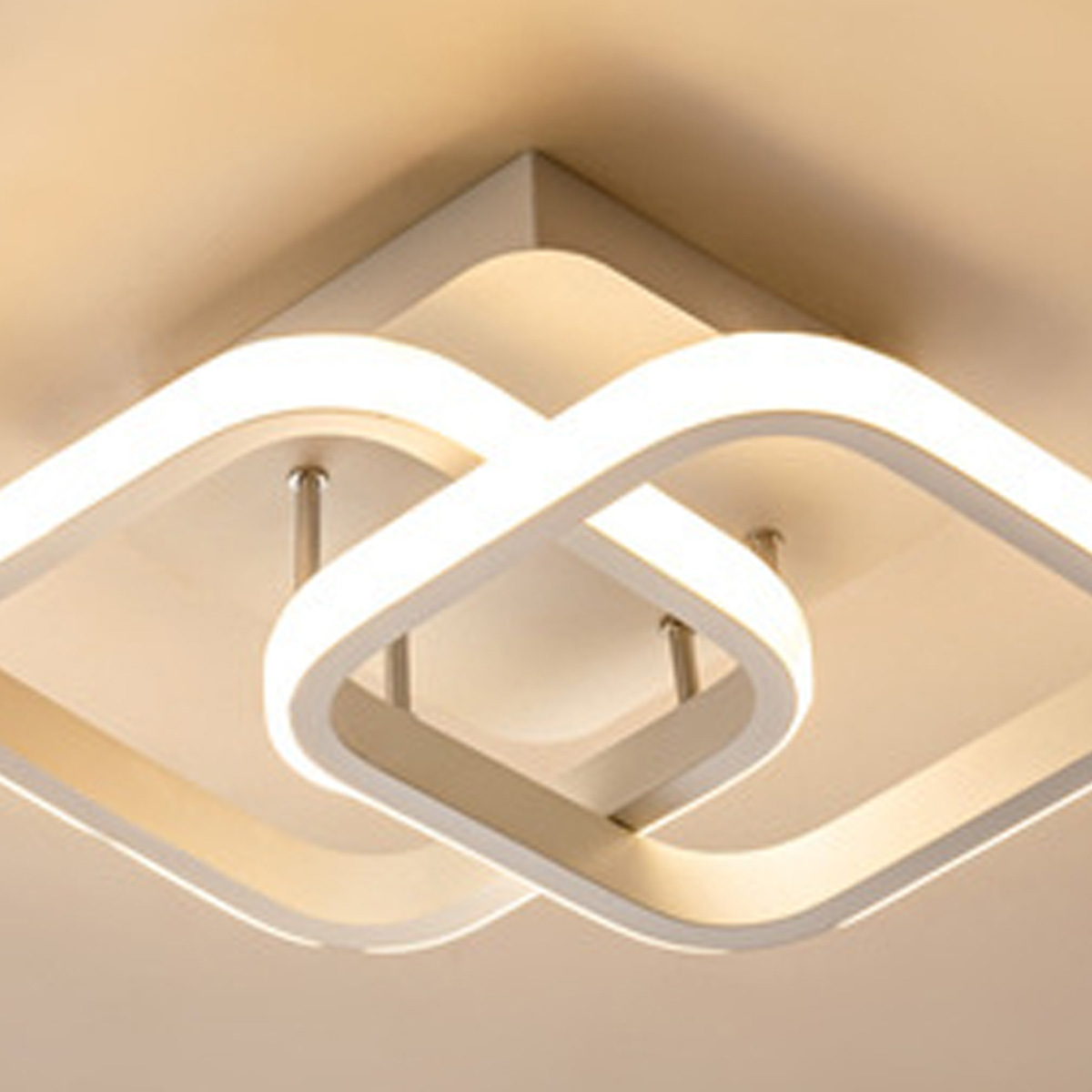 Moderne Deckenleuchte mit verschlungenen weißen Ringen und integriertem Licht.