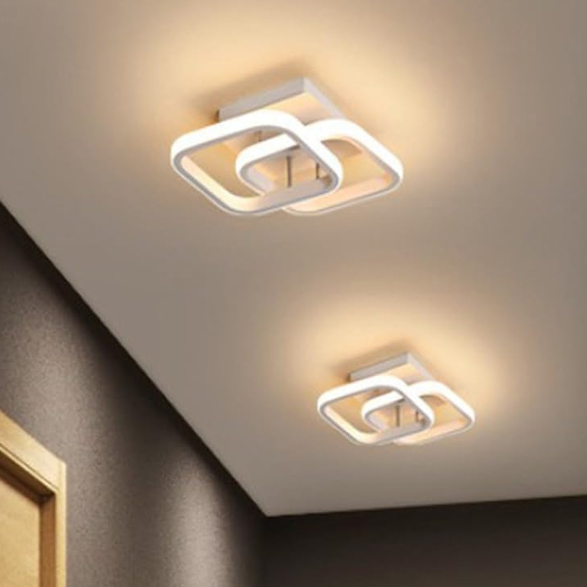 Zwei moderne quadratische Deckenleuchten mit ineinandergreifenden weißen Rahmen und warmer LED-Beleuchtung.