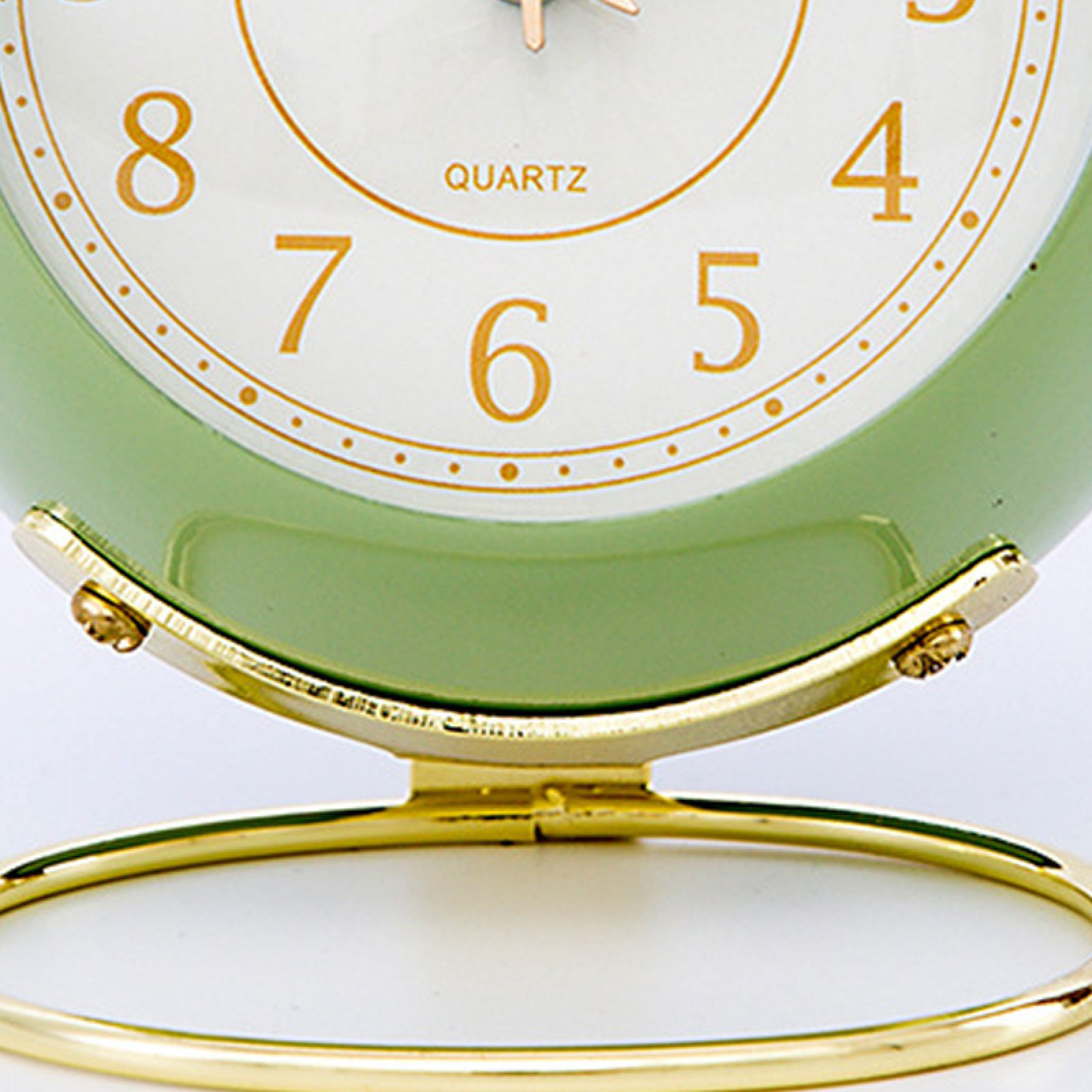 Grüne Uhr mit goldenem Standfuß und Ziffernblatt. Zahlen 4-8 sind sichtbar.