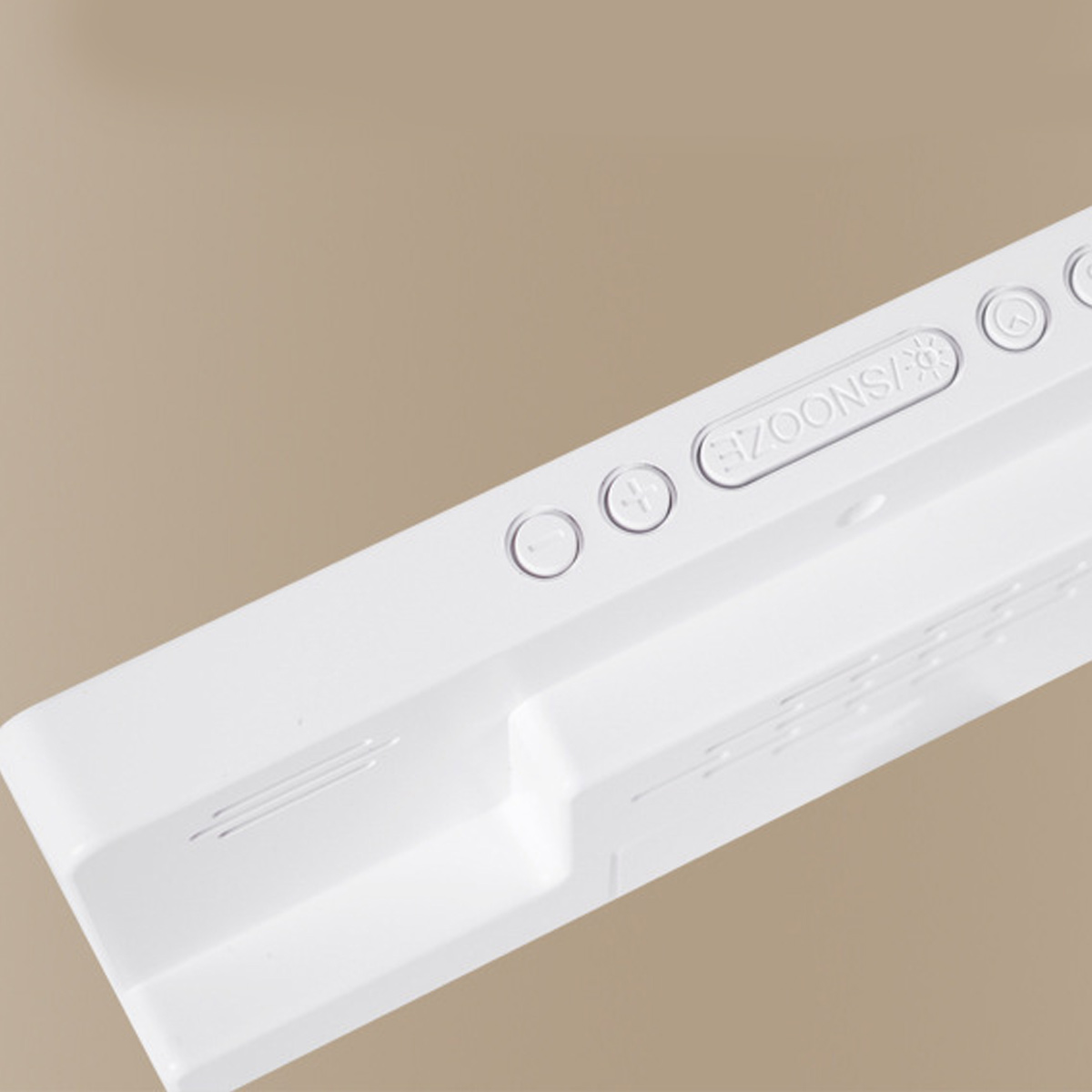Naheaufnahme einer weißen digitalen Uhr mit Snooze-Taste und anderen Bedienelementen.