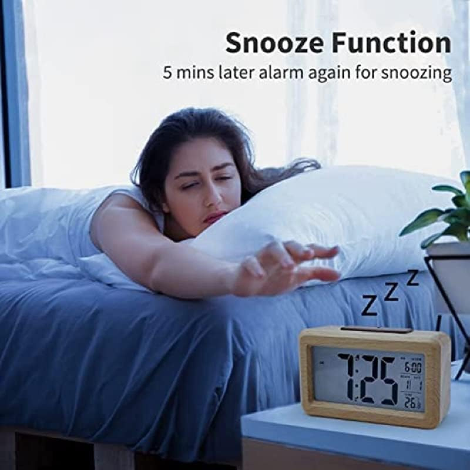 Frau versucht, den Snooze-Knopf eines digitalen Weckers auf einem Nachttisch zu erreichen.
