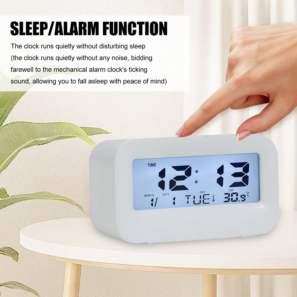 Eine weiße Digitaluhr zeigt 12:13 Uhr, Dienstag und 30,9°C an. Ein Finger drückt oben.