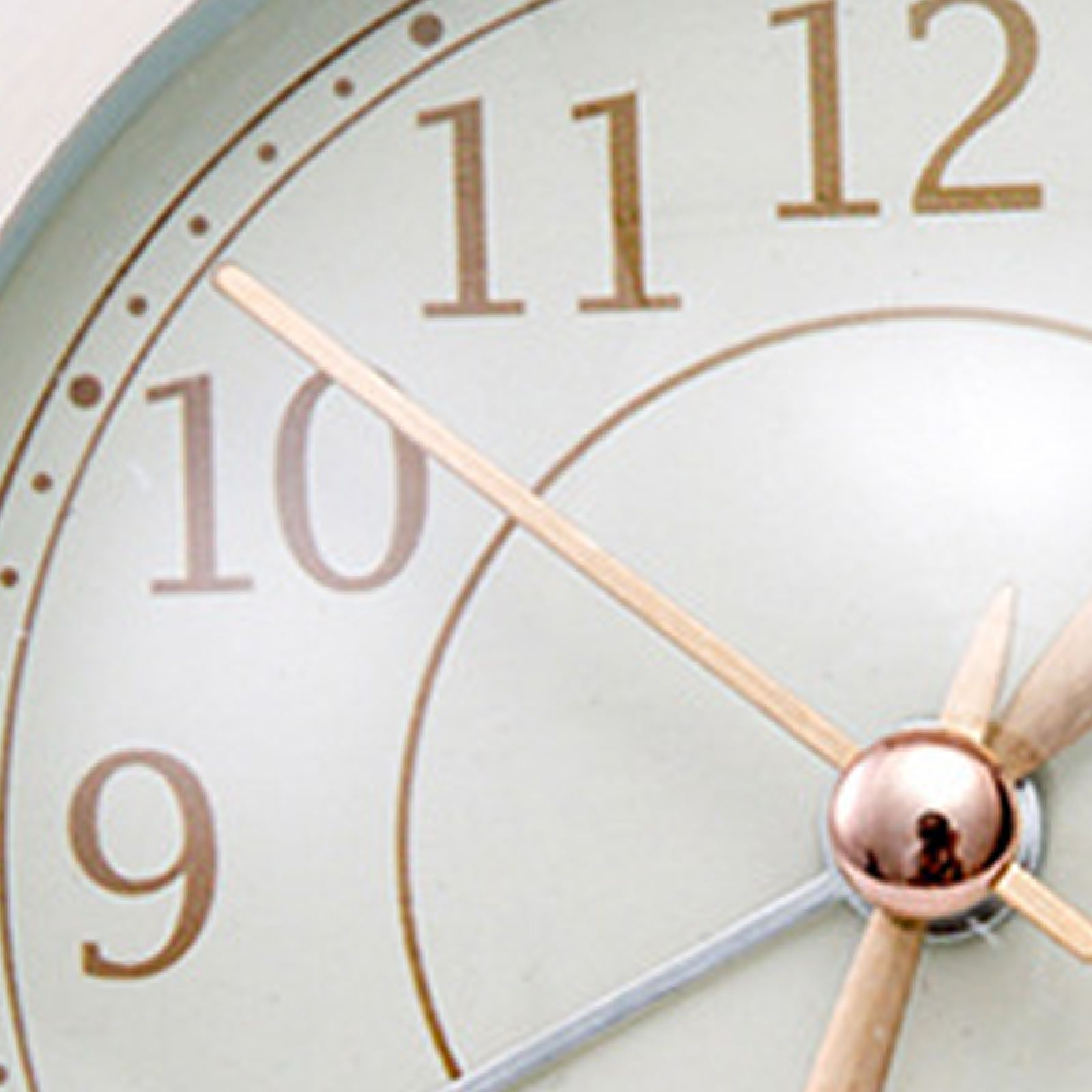 Nahaufnahme einer Uhr mit goldenen Ziffern 9, 10, 11, 12 und hölzernen Zeigern.