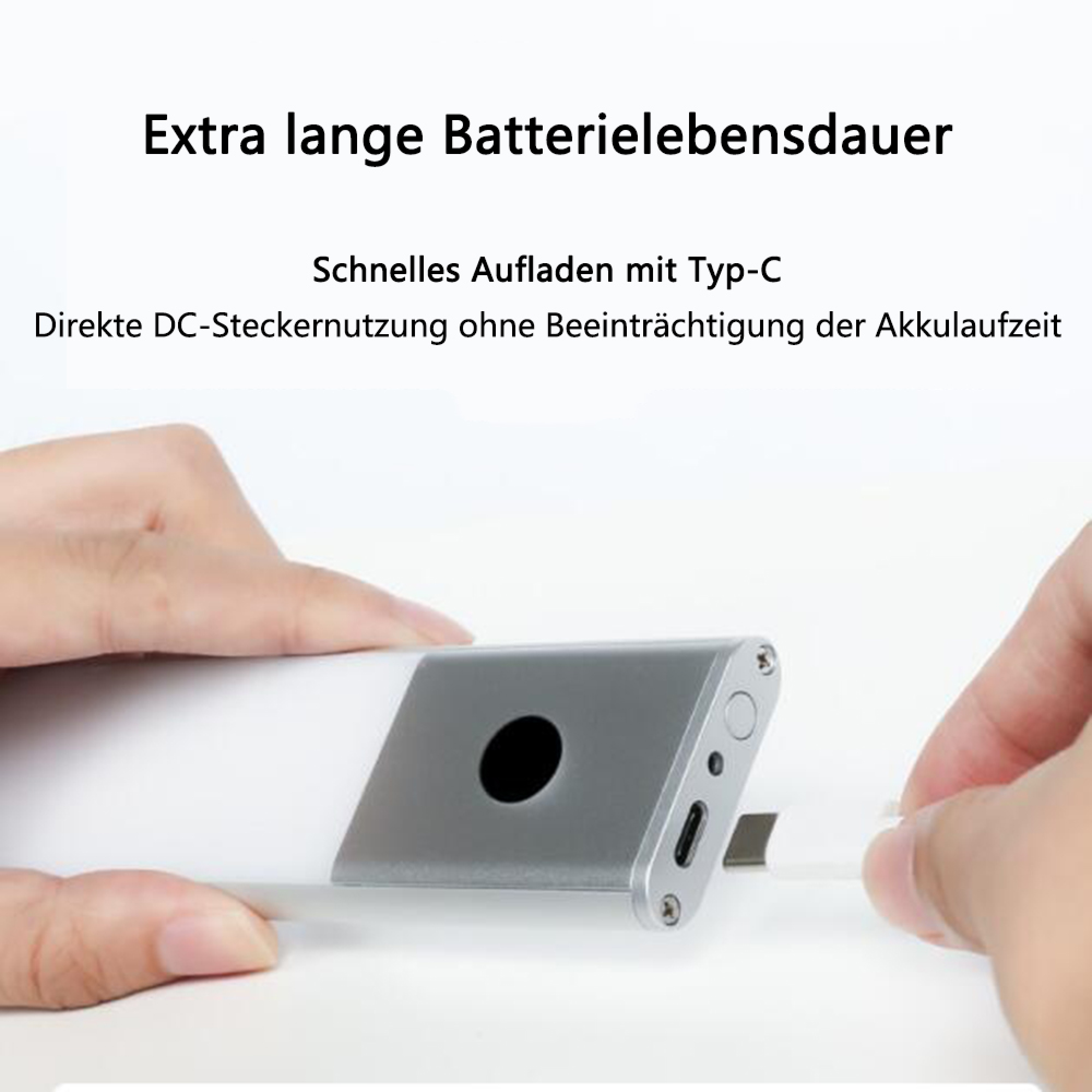 Eine Hand steckt ein weißes USB-C-Kabel in ein silbernes Ladegehäuse.