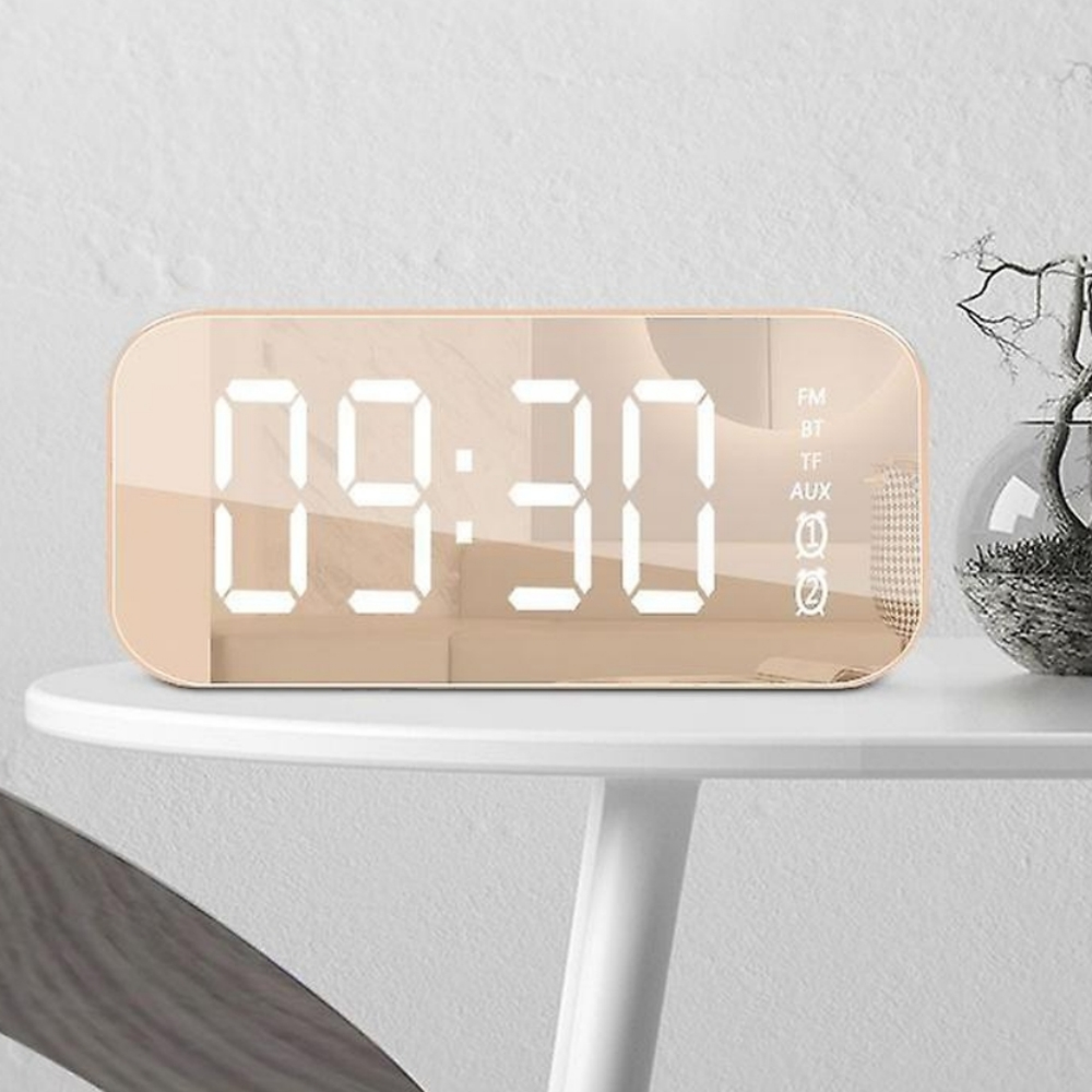 Ein digitaler Wecker zeigt 09:30 an. Er steht auf einem weißen Tisch.
