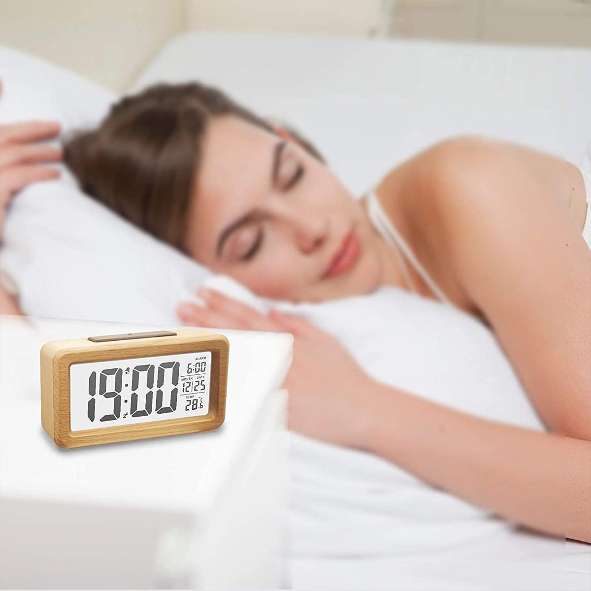 Eine Frau schläft, während ein hölzerner Digitalwecker 19:00 anzeigt.