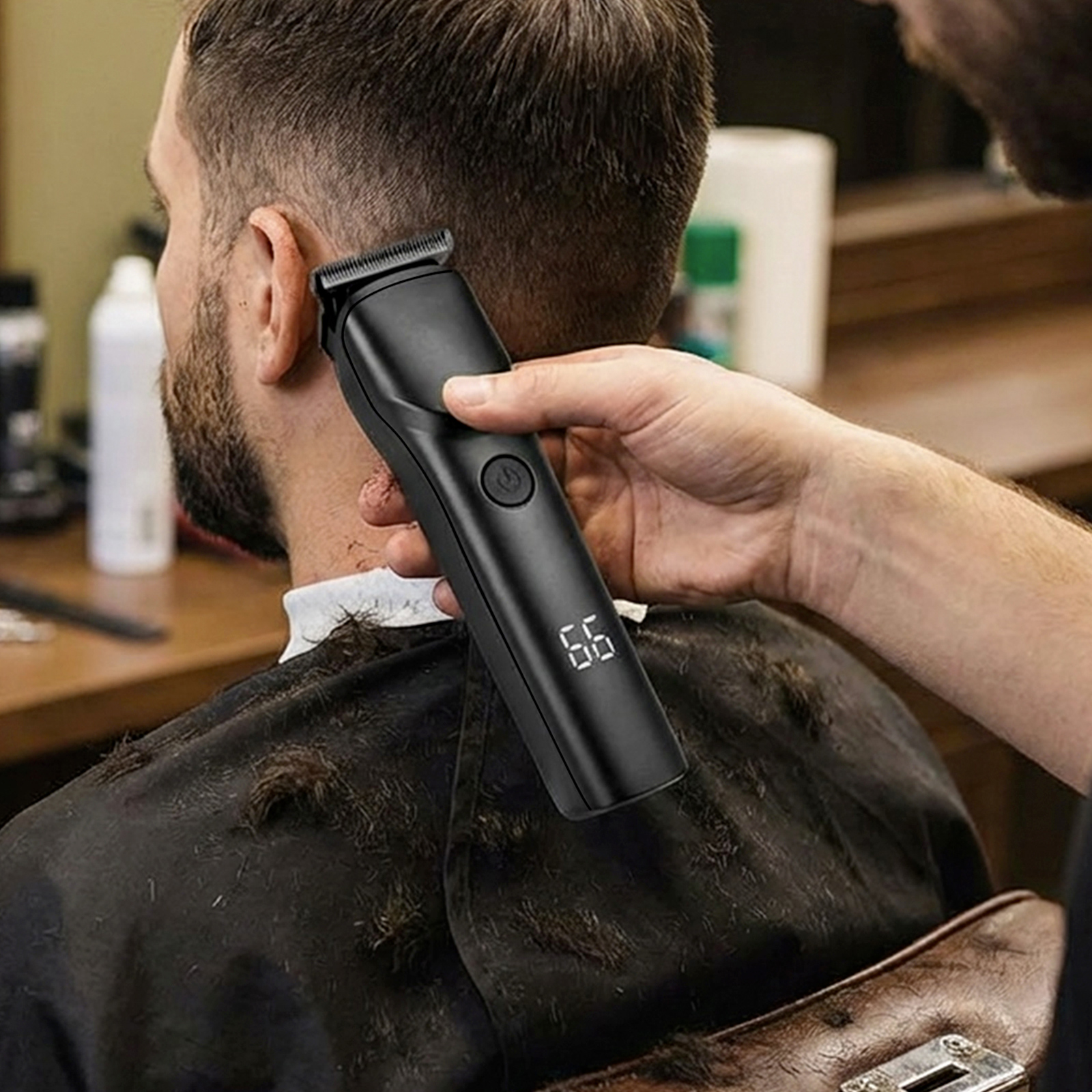 Ein schwarzer Haarschneider wird benutzt, um das Haar eines Mannes zu schneiden.