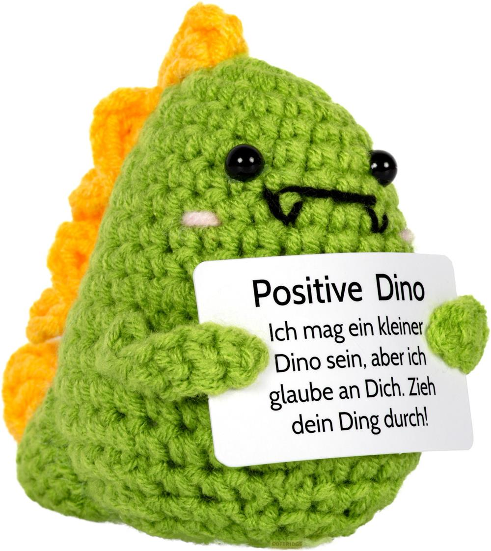 Un dinosaure vert au crochet avec une crête dorsale jaune tient une pancarte "Positive Dino".