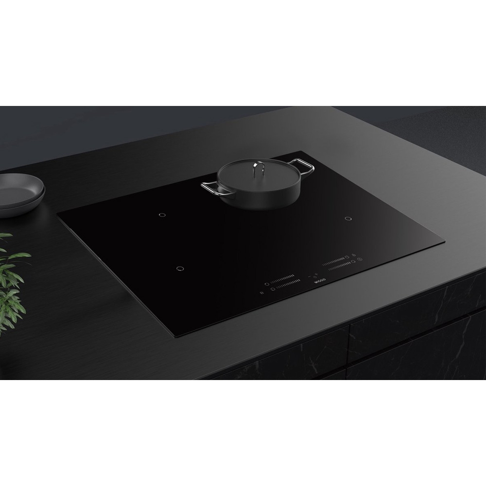 Zwart inductiefornuis met pan. Moderne keuken met marmeren aanrechtblad.
