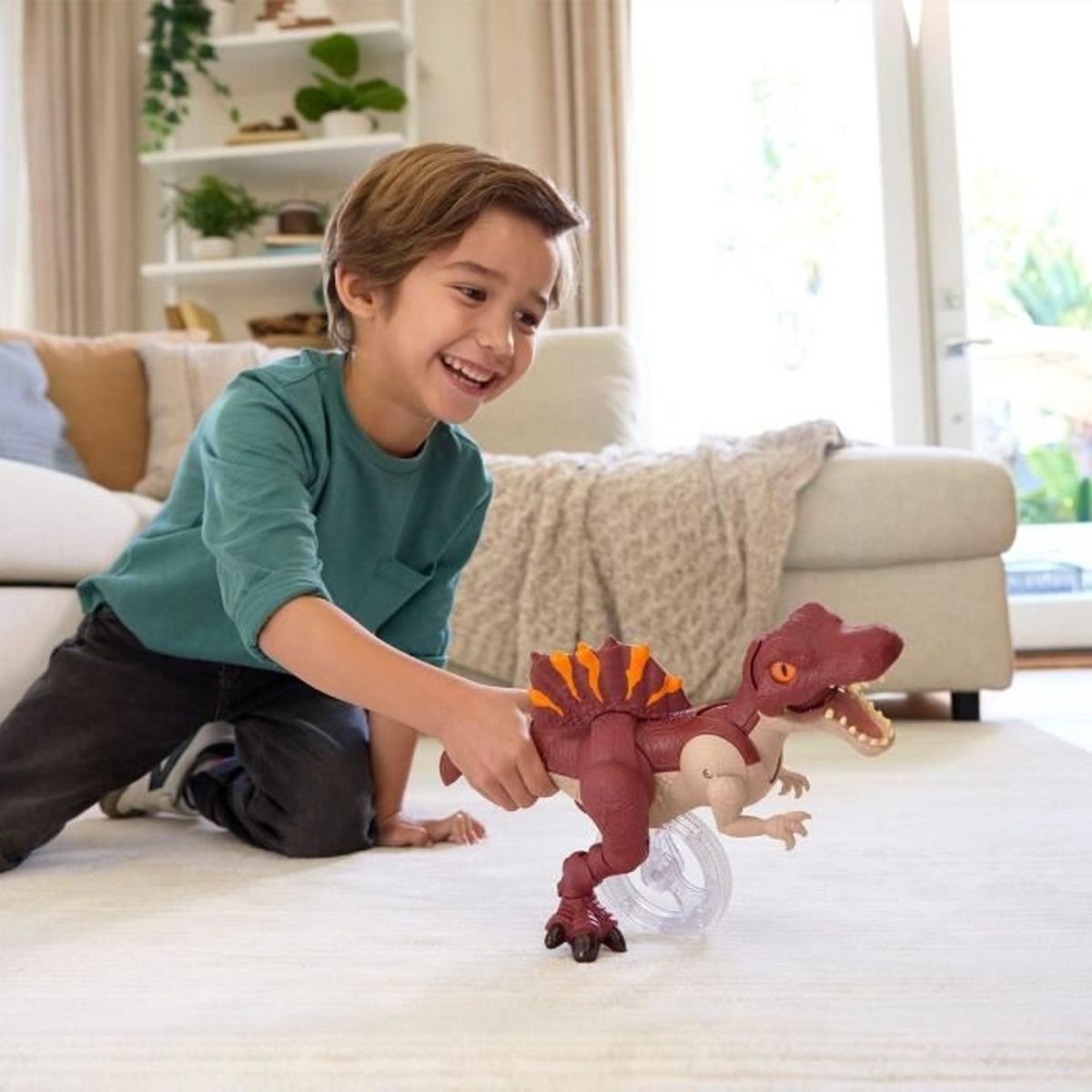 Ein Junge spielt mit einem roten Dinosaurierspielzeug mit orangefarbenen Streifen.
