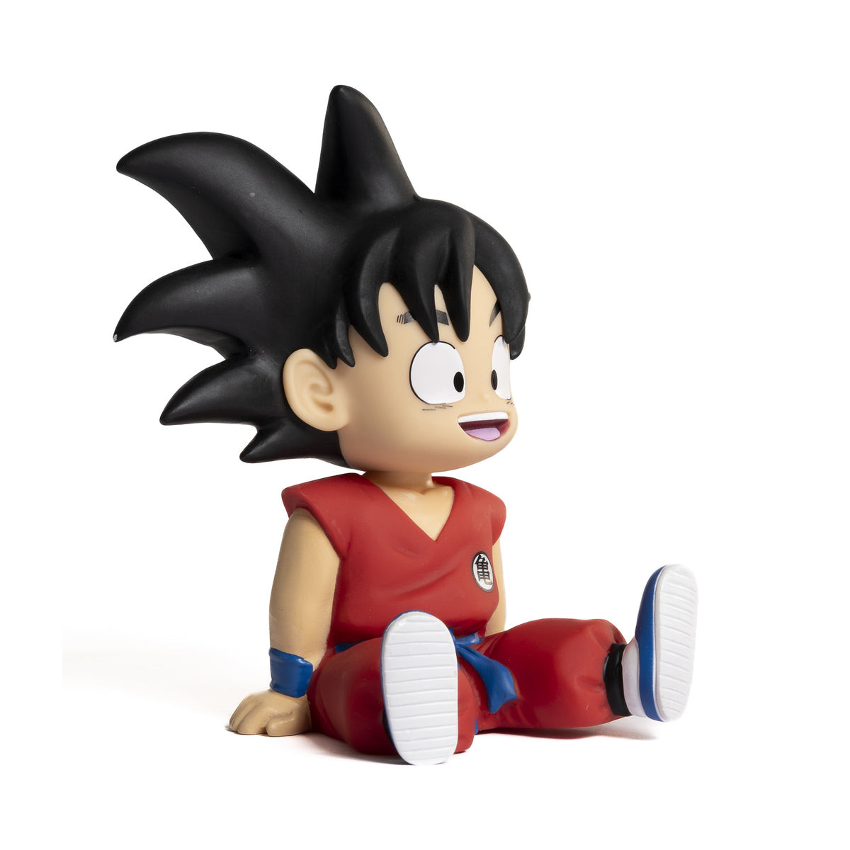 Una figura de Goku con ropa roja se sienta con las piernas extendidas. Zapatos blancos, cinturón azul.