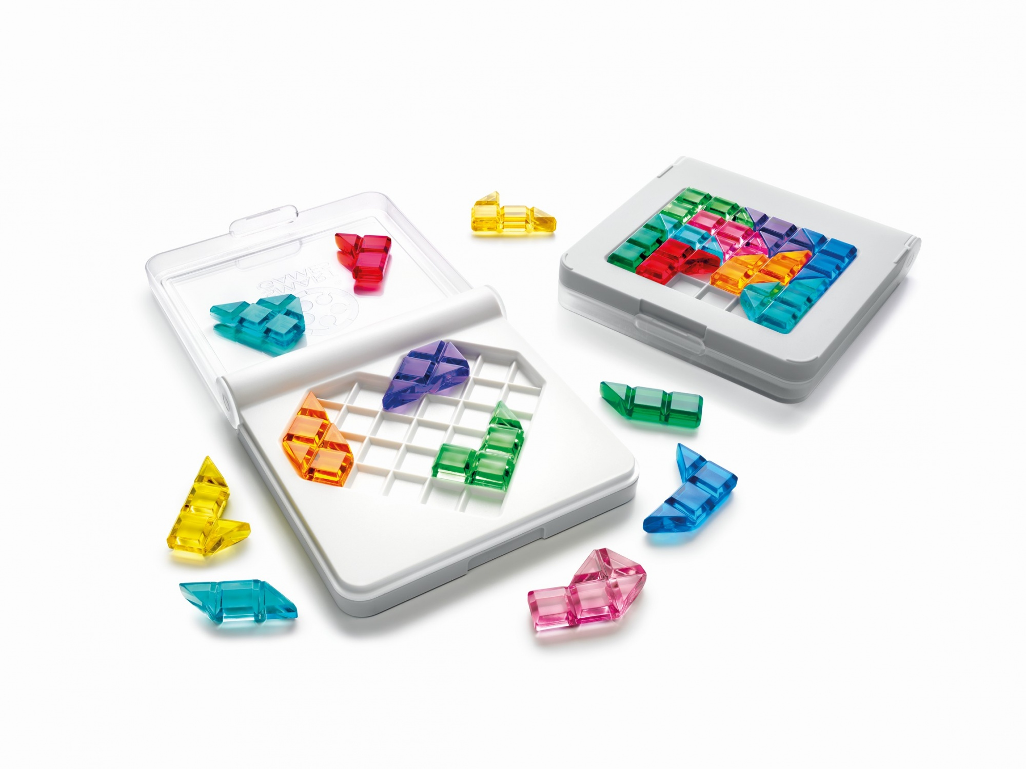 Piezas de rompecabezas transparentes de varios colores y formas sobre y junto a dos tableros de juego blancos.