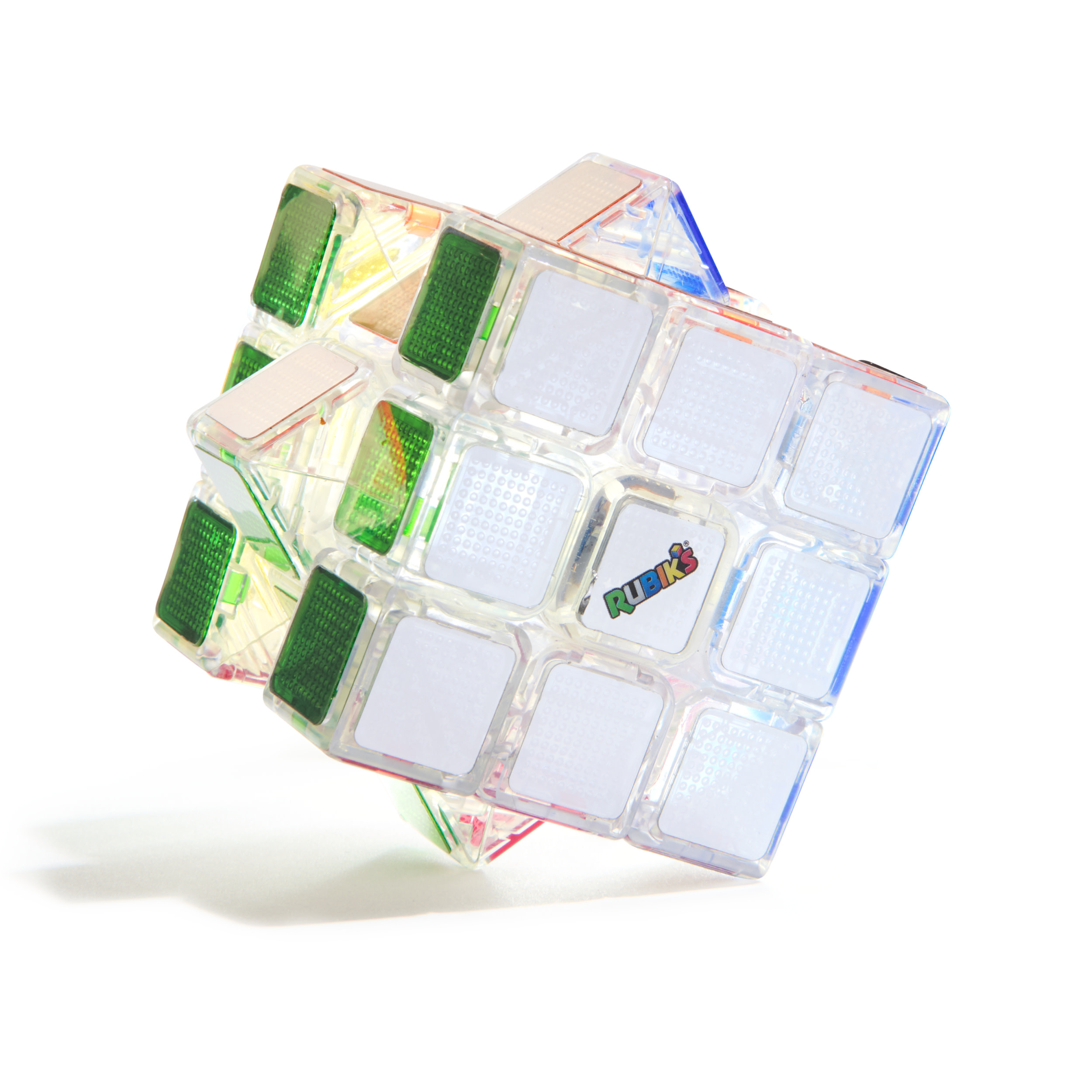 Un cubo de Rubik transparente con caras verdes y blancas yace sobre fondo blanco.